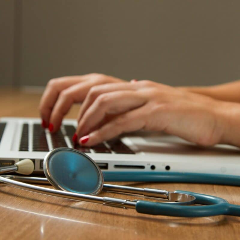 a doctor typing on a laptop