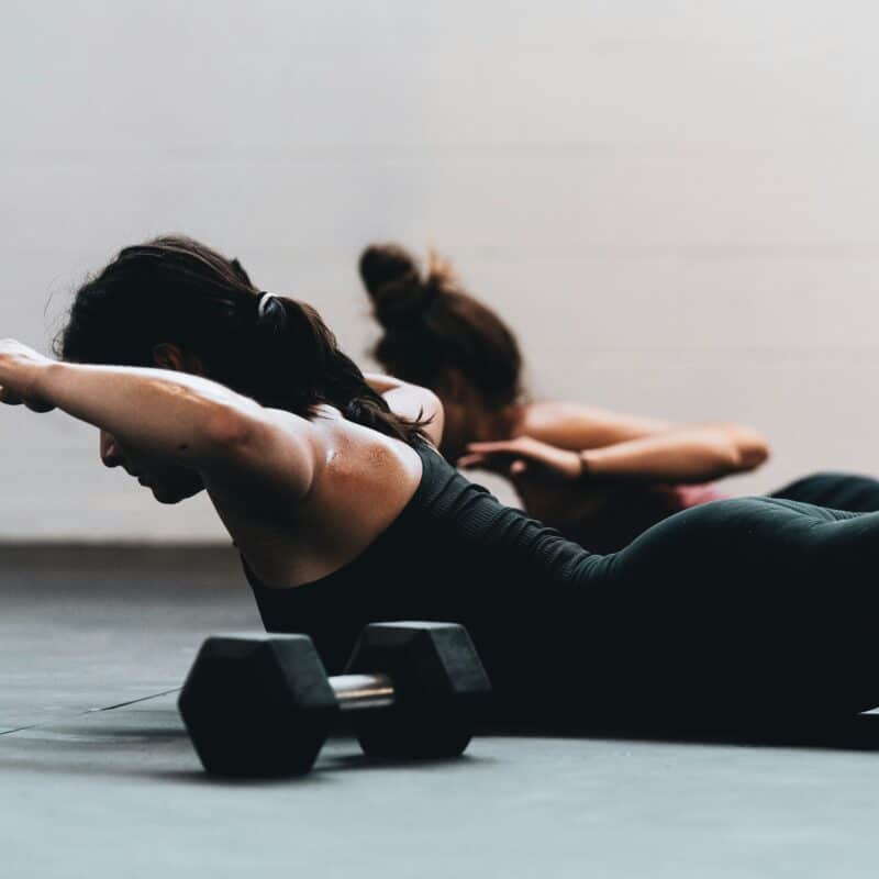 Women performing physical therapy exercises with dumbbells to enhance mobility and manage endometriosis symptoms.