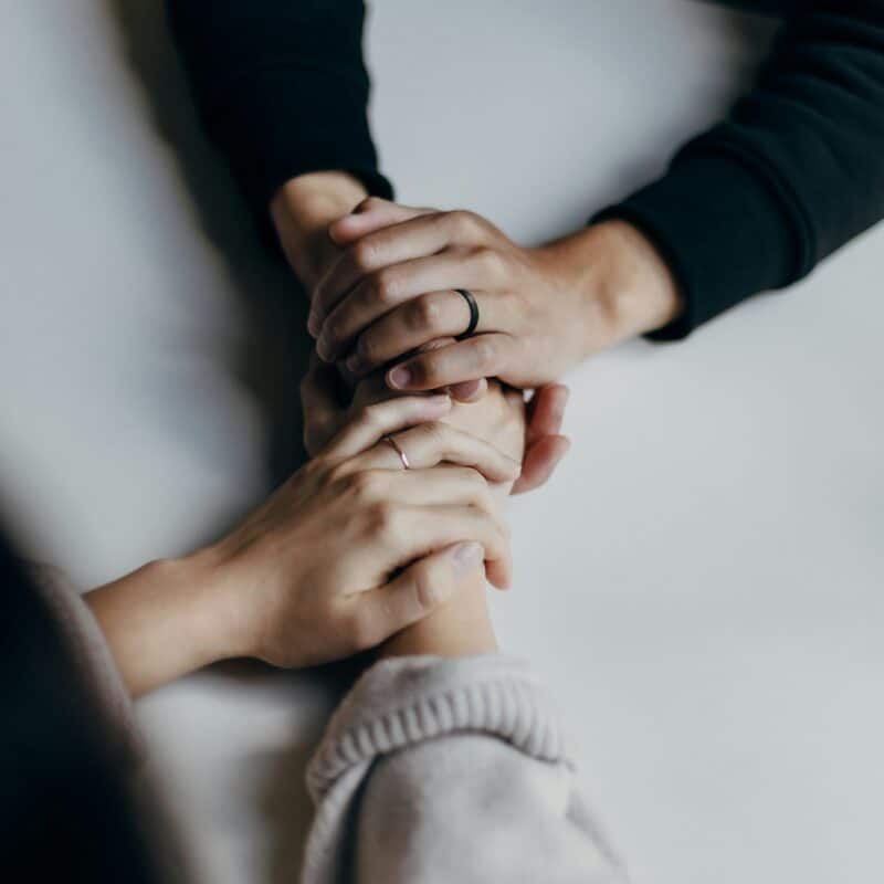 two people supporting each other hand in hand