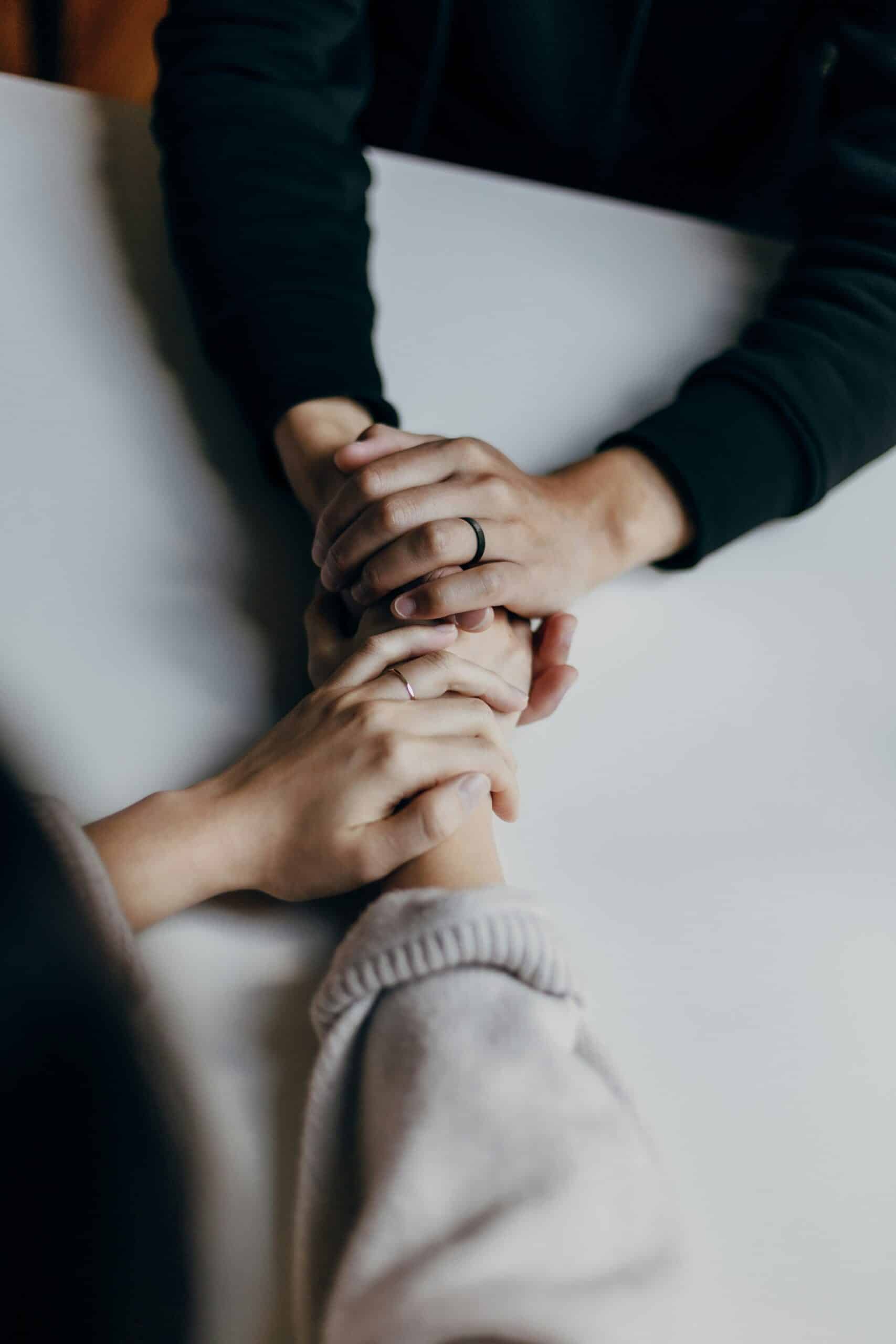 two people supporting each other hand in hand