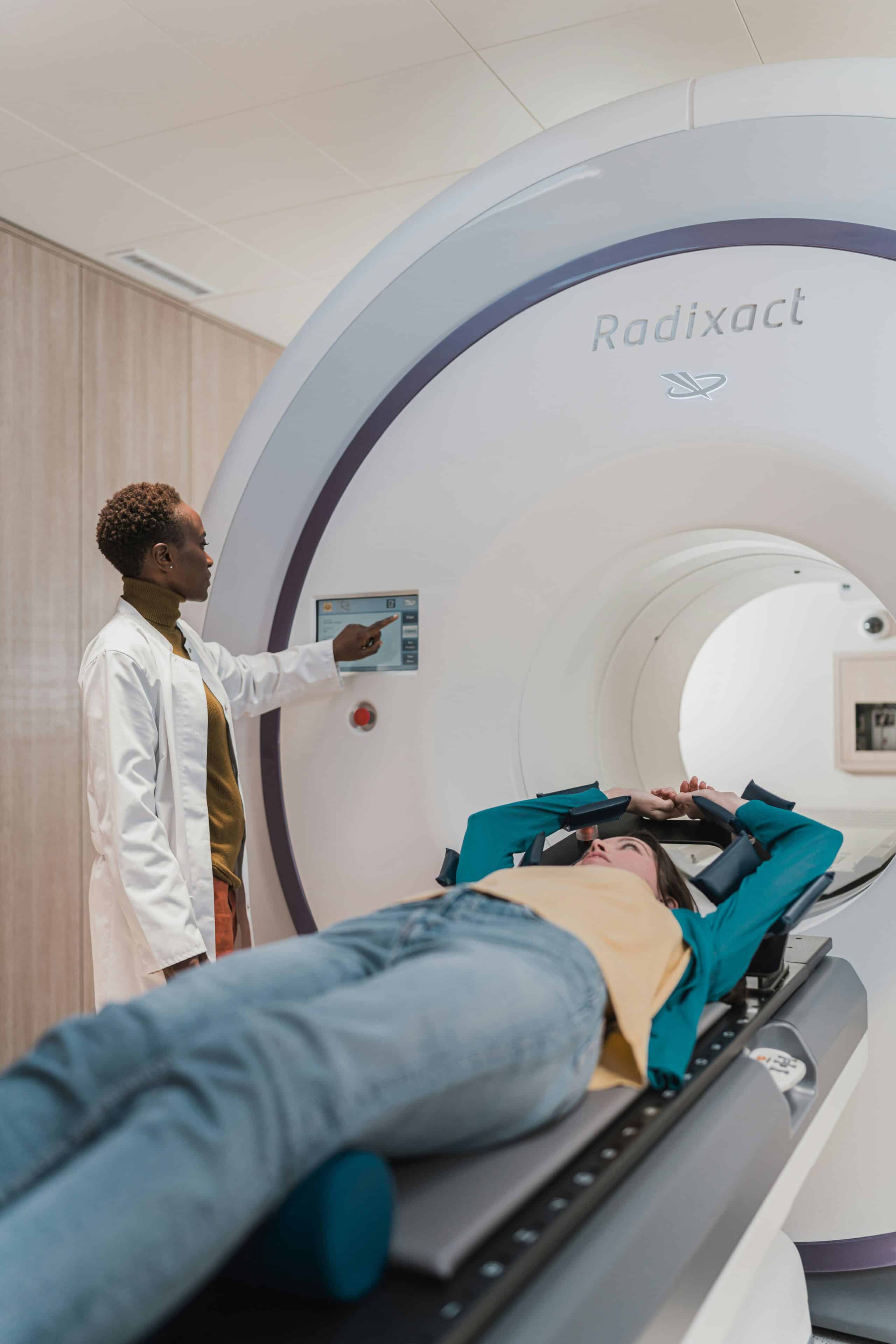A doctor operating an advanced medical imaging machine while a patient lies inside, representing a comparison between laparoscopy and other diagnostic methods for endometriosis. - Rachael Haverland Site A doctor operating an advanced medical imaging machine while a patient lies inside, representing a comparison between laparoscopy and other diagnostic methods for endometriosis.