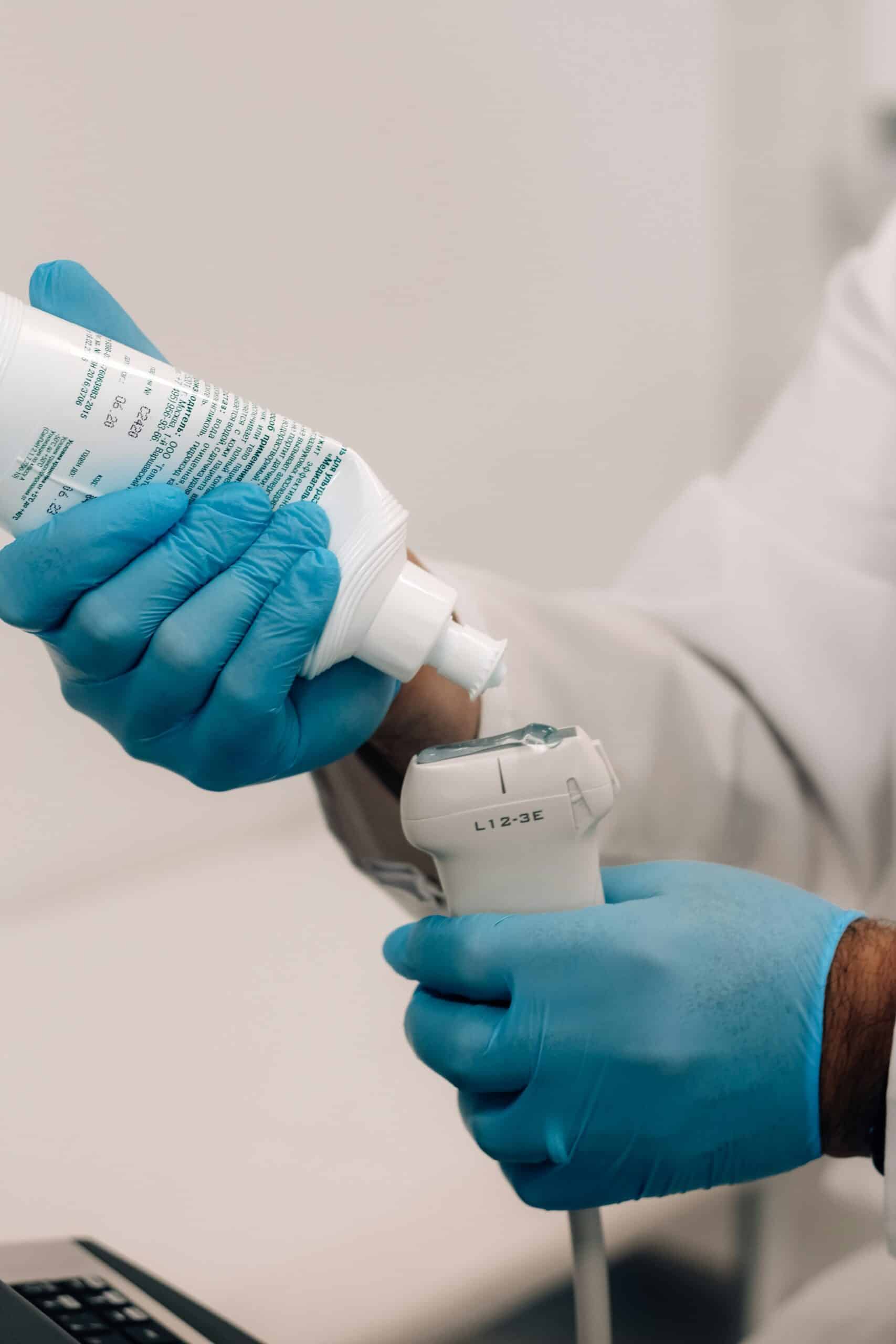 Healthcare professional in blue gloves preparing ultrasound gel for pelvic ultrasound examination, relevant to endometriosis diagnostics for adolescents.