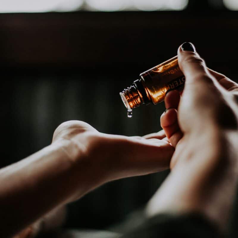 Person pouring CBD oil onto their hand, highlighting its use for pain relief and inflammation management in endometriosis.