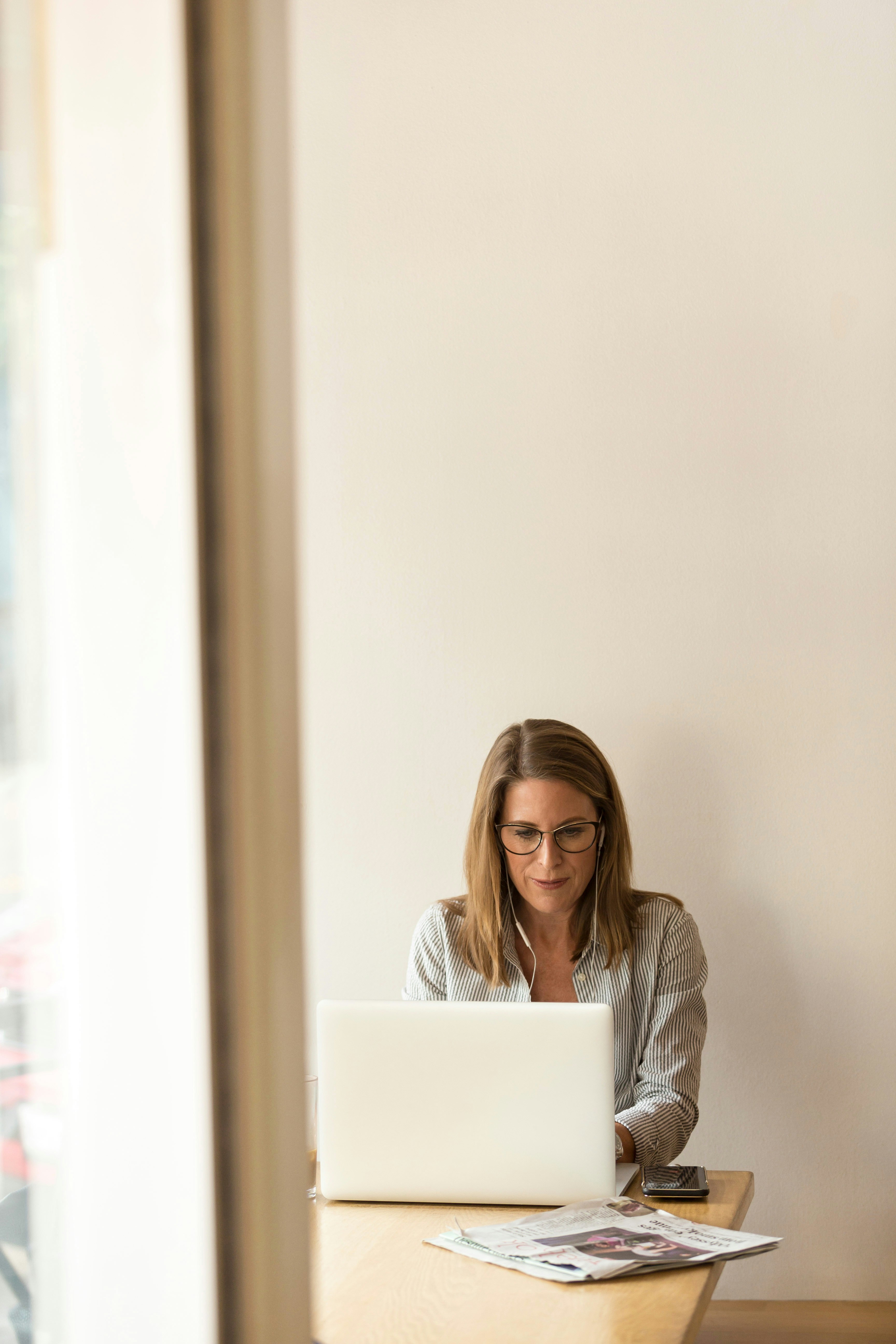 A person working on a laptop, possibly researching financial aid resources or engaging in administrative tasks, demonstrating the accessibility of online tools for endometriosis patients seeking support.