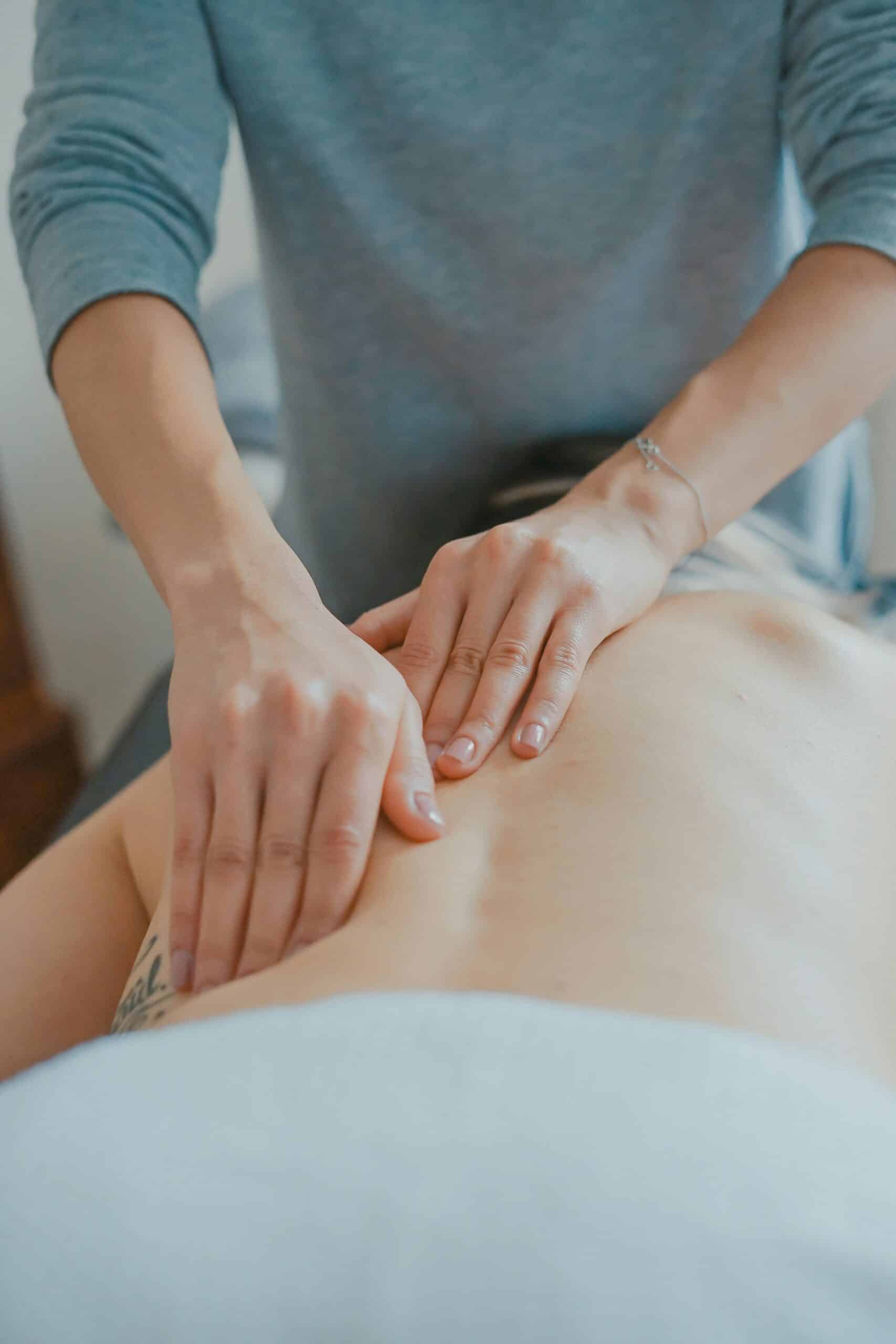 A healthcare professional providing a back massage, which can help alleviate pain and tension, potentially offering relief for conditions like endometriosis.