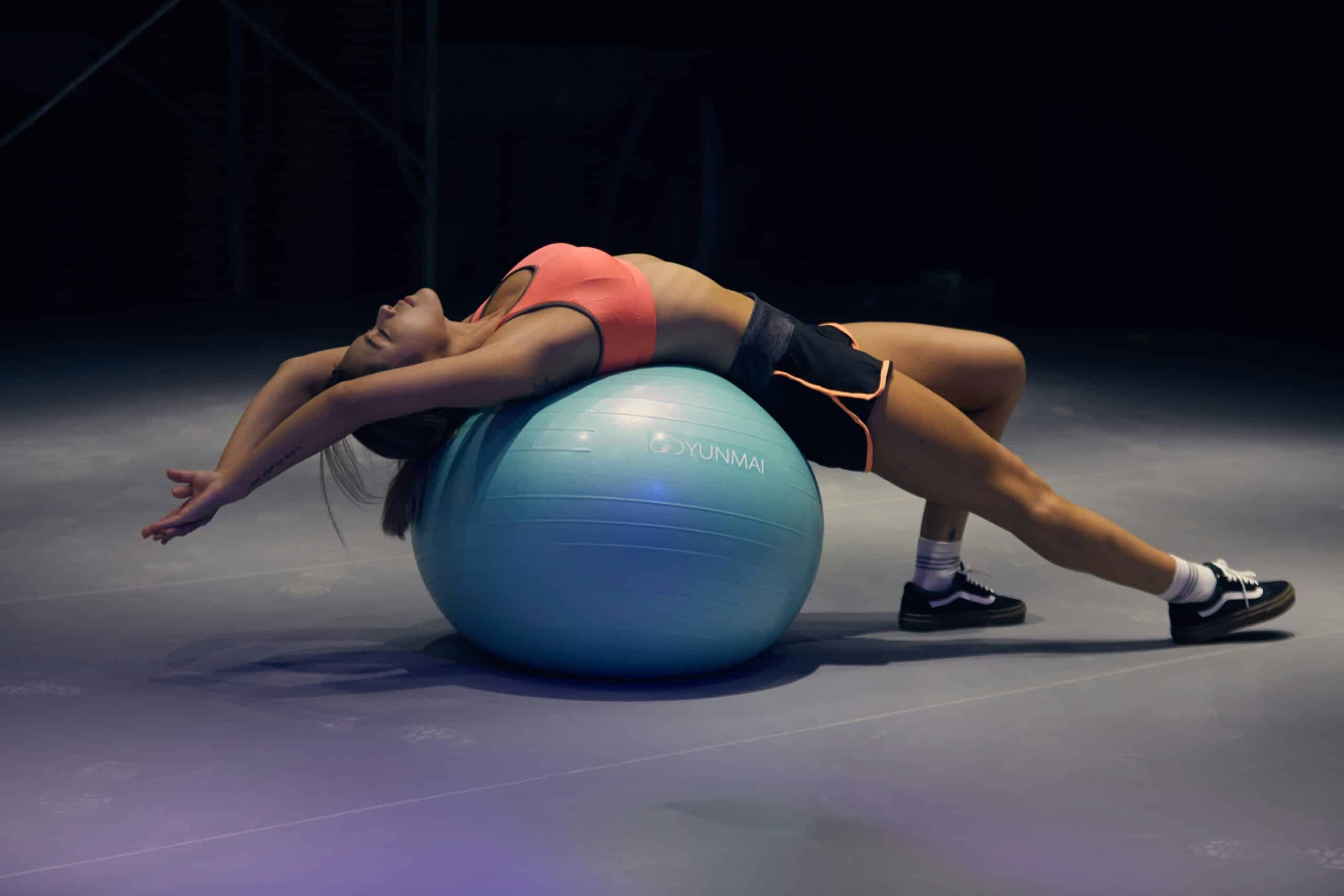 A person performing a stretch or exercise on a stability ball, which can support pelvic floor therapy and enhance flexibility, offering potential relief from endometriosis symptoms.