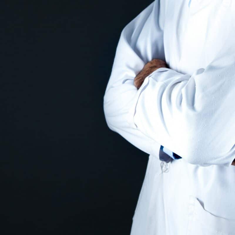 Doctor holding stethoscope with arms crossed.