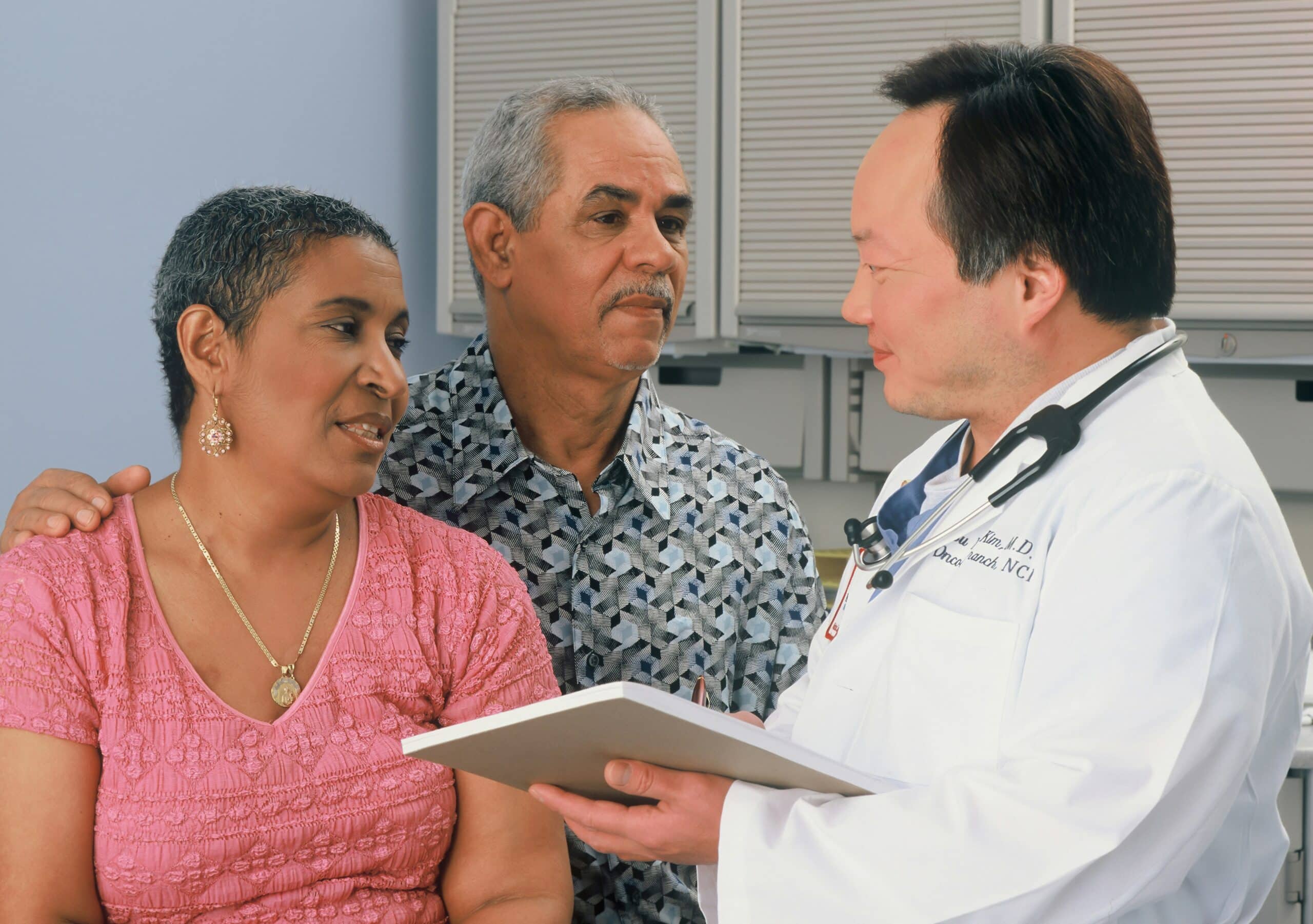 A healthcare professional discussing with a couple, demonstrating the importance of communication and support when seeking resources, such as financial aid, for managing endometriosis.