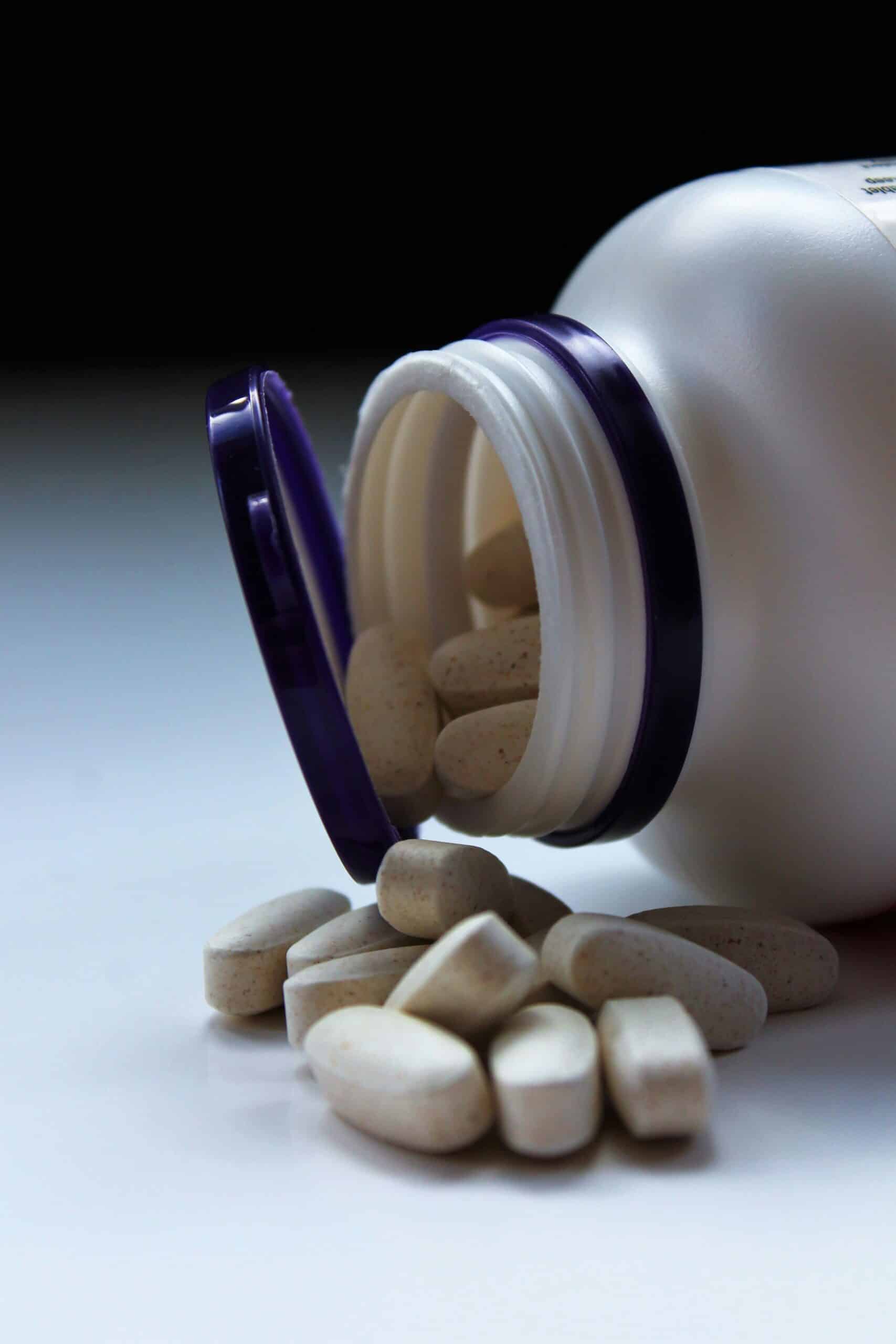 A bottle of dietary supplements spilling onto a surface, emphasizing the role of essential minerals in supporting endometriosis relief and overall well-being. - Rachael Haverland Site A bottle of dietary supplements spilling onto a surface, emphasizing the role of essential minerals in supporting endometriosis relief and overall well-being.