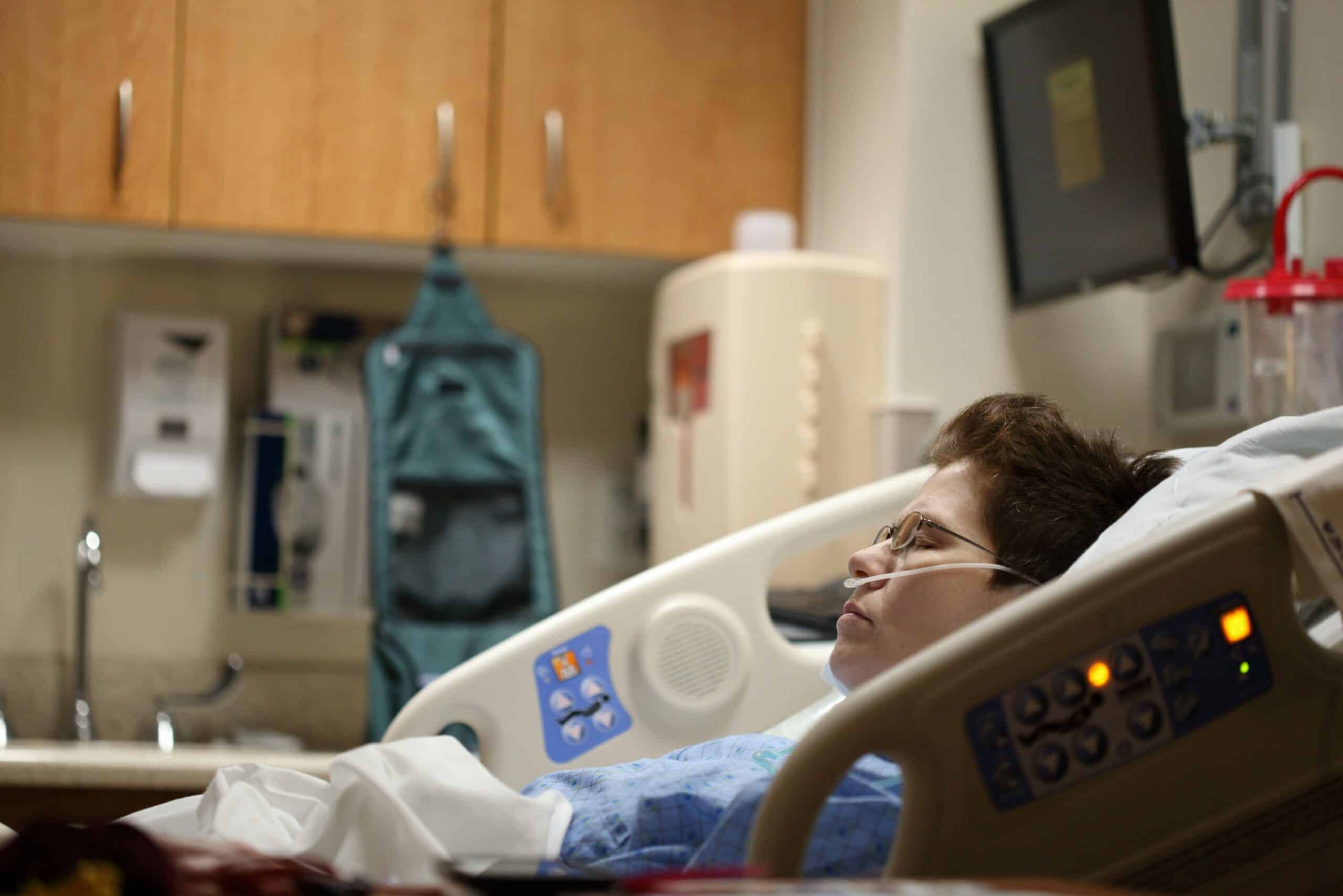 A patient lying in a hospital bed with an oxygen tube, representing the potential risks and considerations associated with medical procedures. - Rachael Haverland Site A patient lying in a hospital bed with an oxygen tube, representing the potential risks and considerations associated with medical procedures.