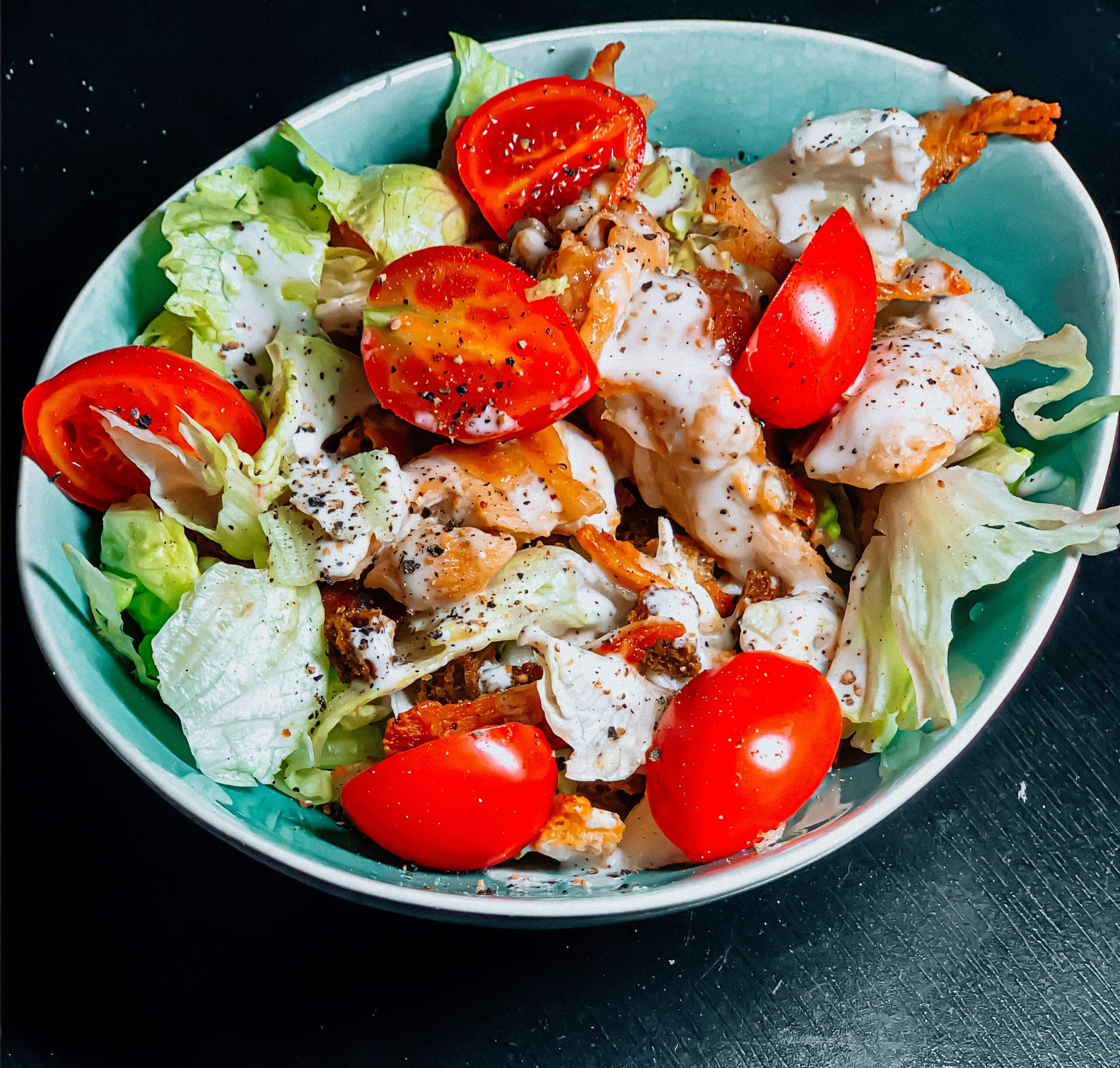 A fresh salad with cherry tomatoes, lettuce, crispy toppings, and a creamy dressing, representing diet considerations for recovery after surgery. - Rachael Haverland Site A fresh salad with cherry tomatoes, lettuce, crispy toppings, and a creamy dressing, representing diet considerations for recovery after surgery.