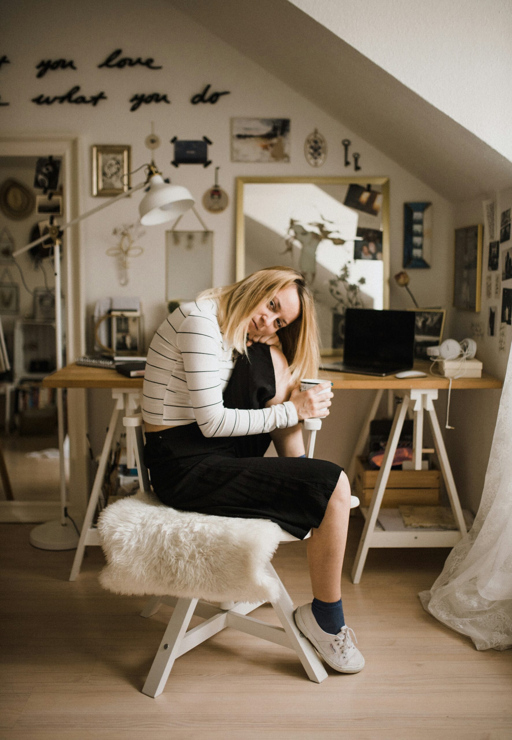 woman sitting at office with a mug, looking reflective - Rachael Haverland Site woman sitting at office with a mug, looking reflective