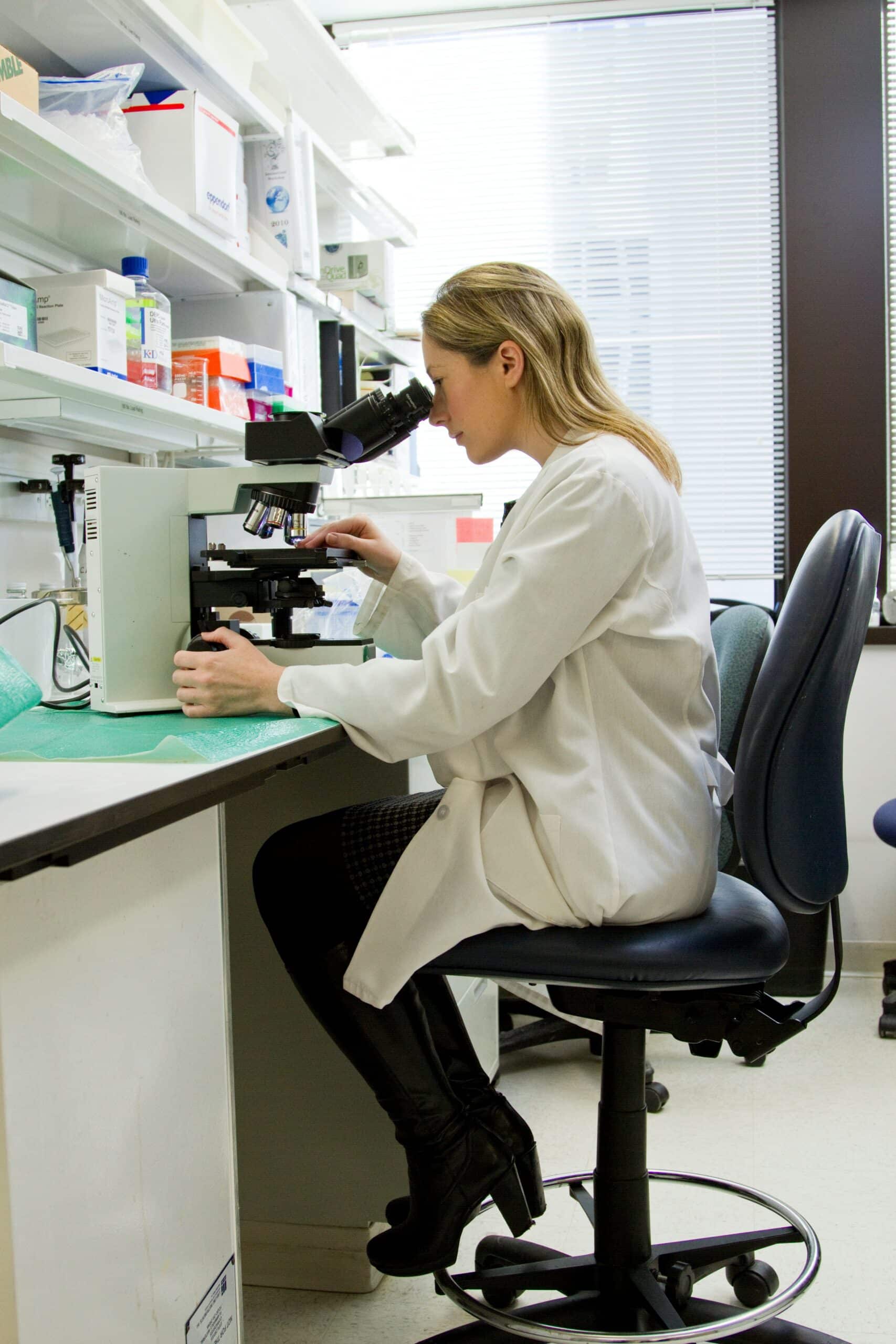 a woman looking under a microscope