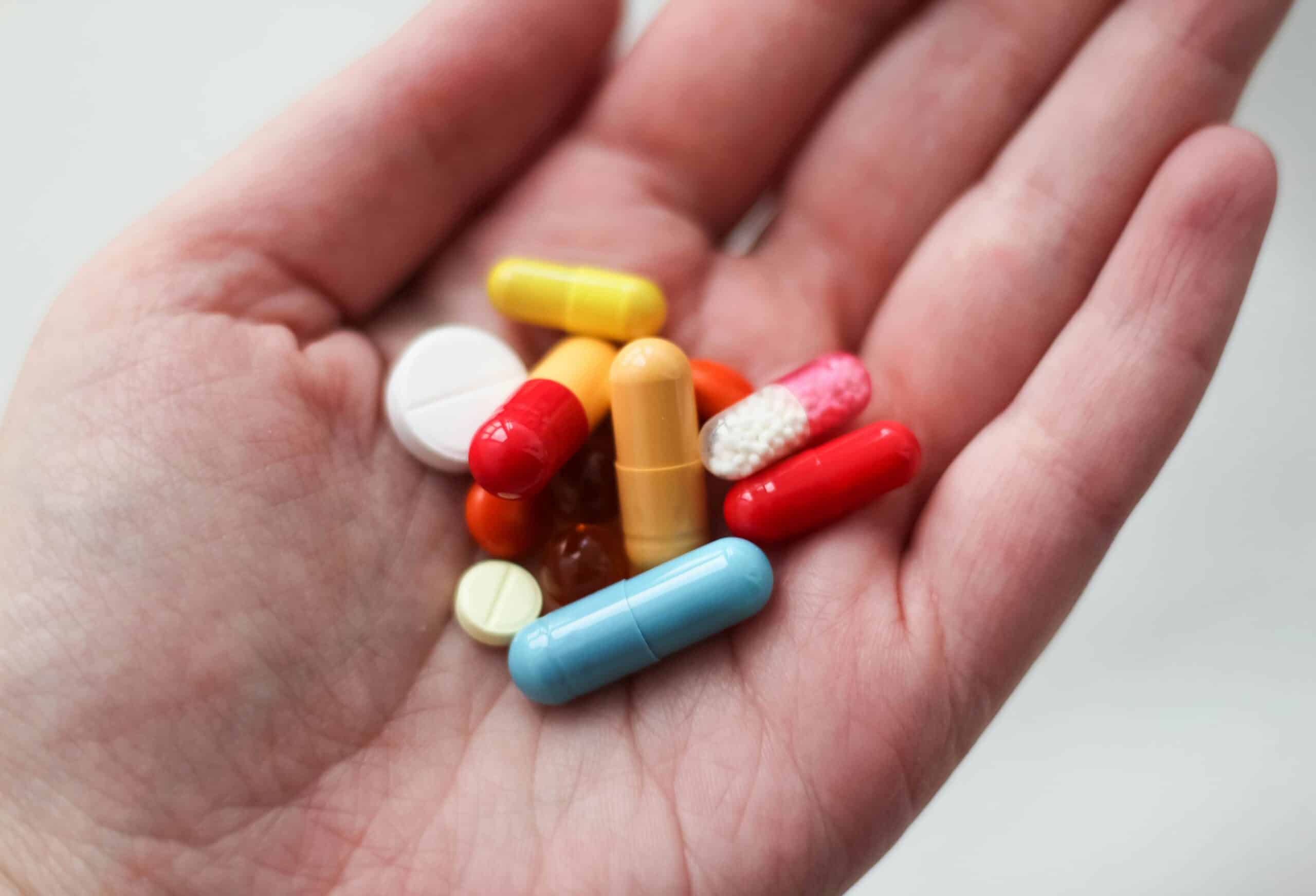 a woman holding medication - Rachael Haverland Site A close-up of a hand holding various pills, illustrating the consideration of progestin-only treatments for managing endometriosis symptoms.