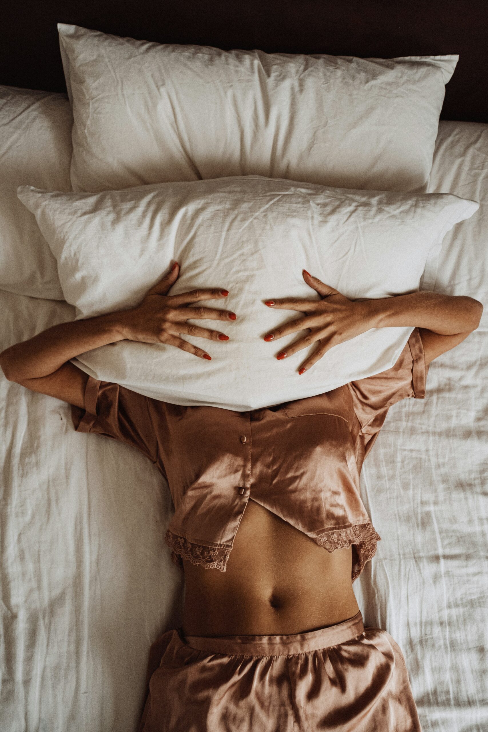 a woman with her face covered with a pillow