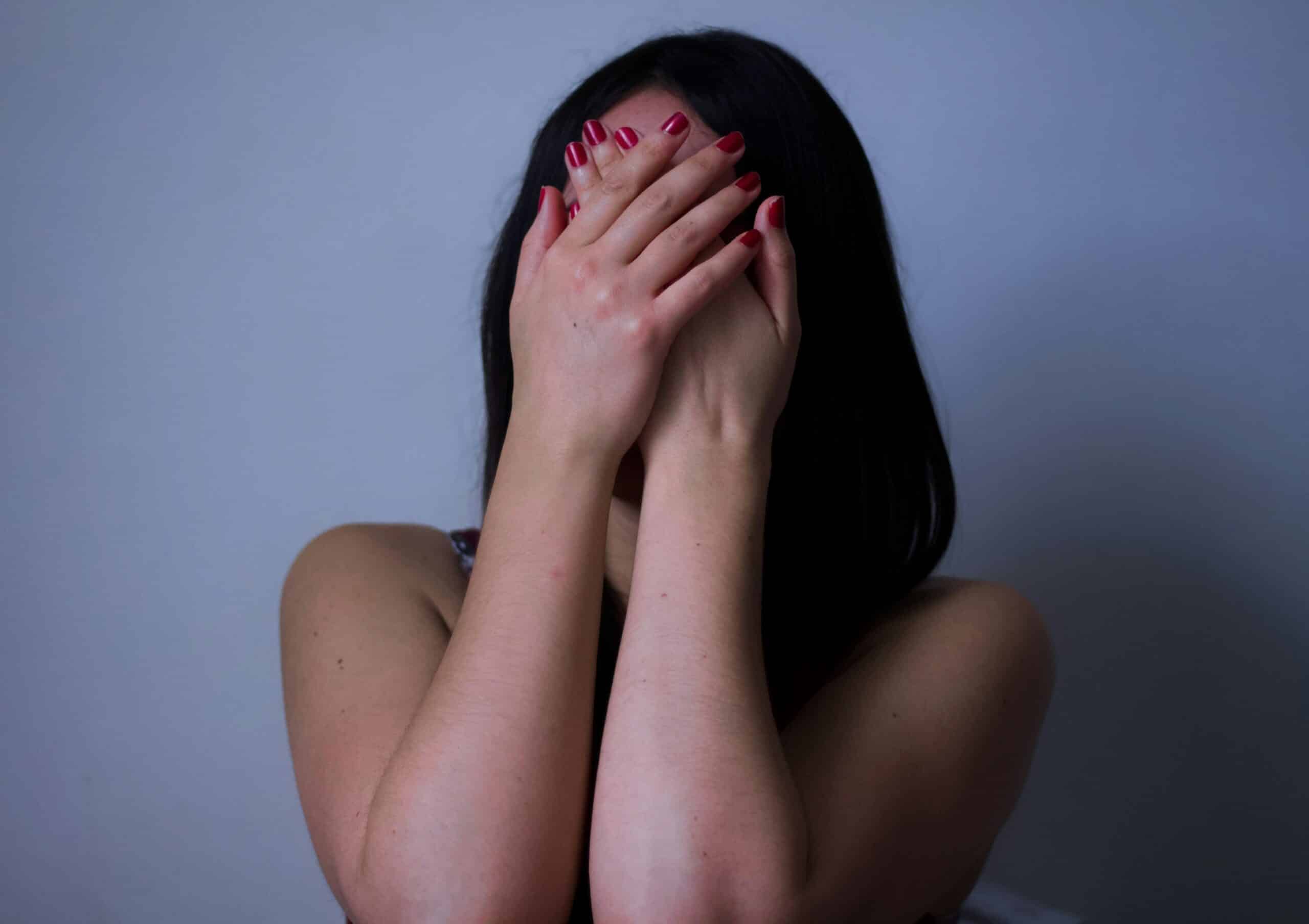 Woman covering her face with both hands, symbolizing emotional distress or discomfort related to menstrual changes from endometriosis.