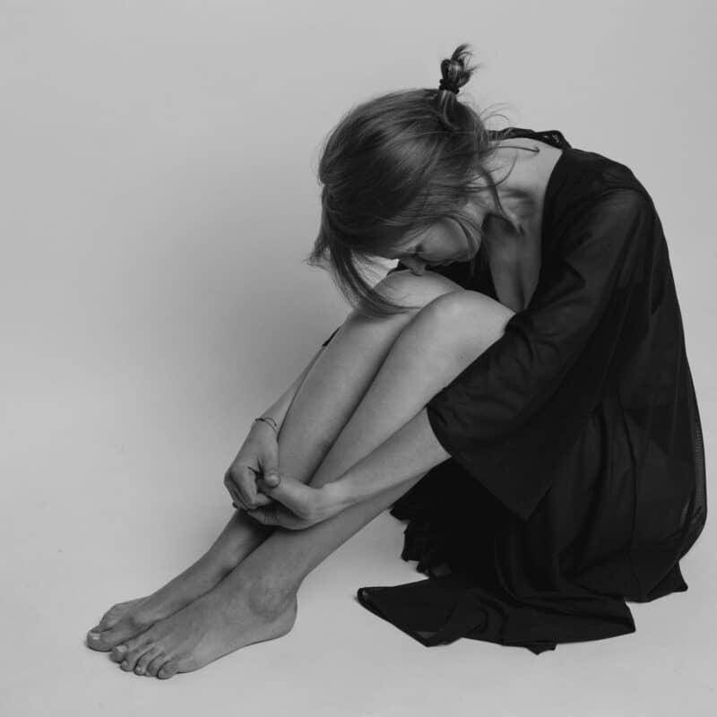 woman sitting on the floor in pain
