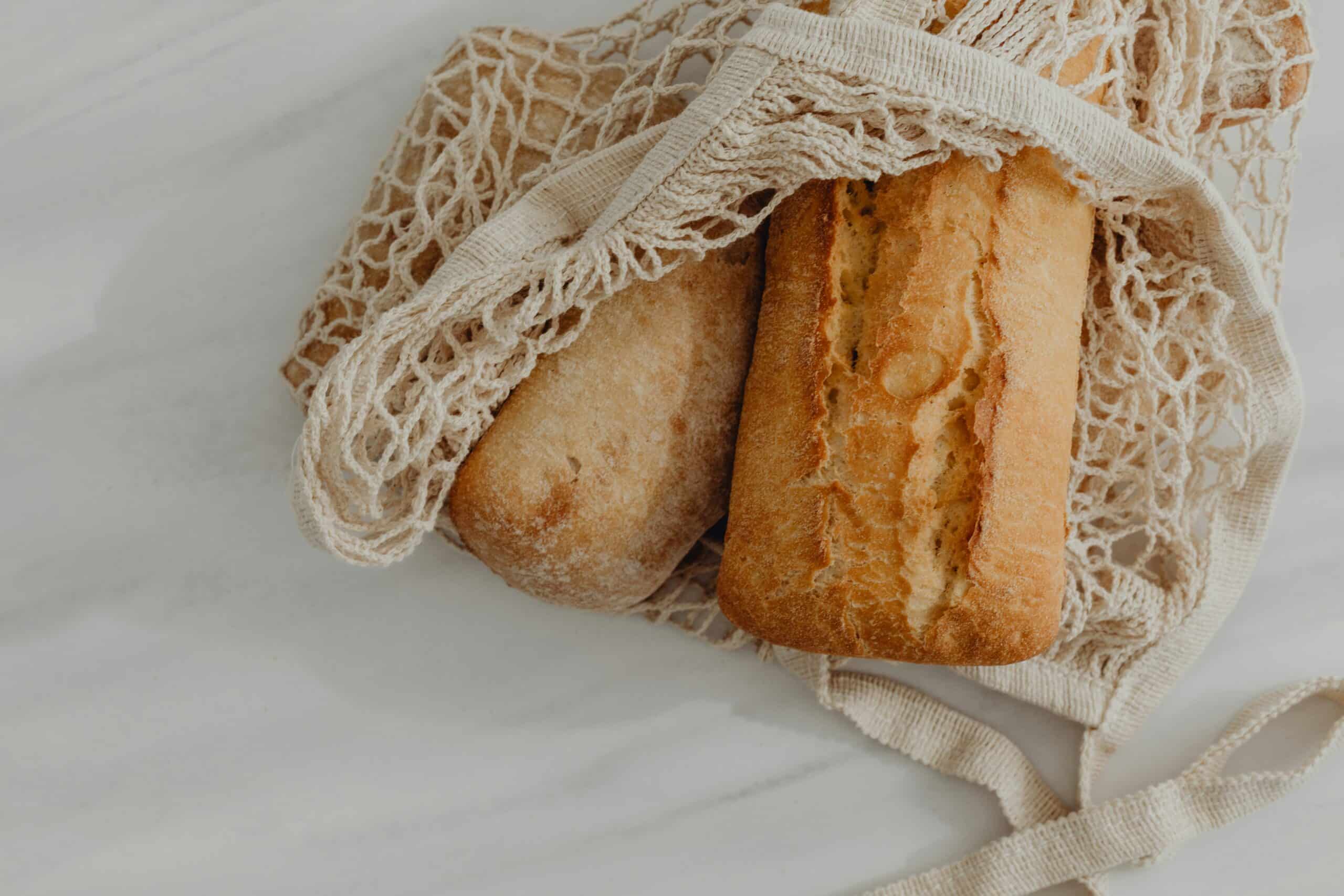 Fresh loaves of bread in a mesh bag suggest dietary gluten as a potential factor in endometriosis-related inflammation and symptoms. - Rachael Haverland Site Fresh loaves of bread in a mesh bag suggest dietary gluten as a potential factor in endometriosis-related inflammation and symptoms.