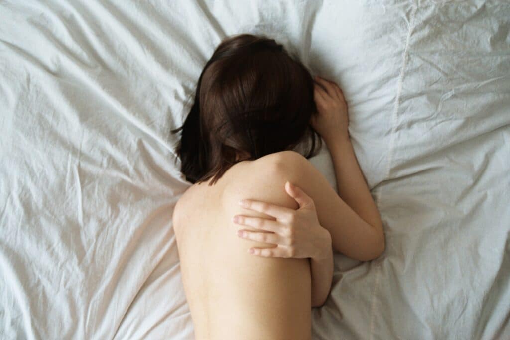 A woman resting in bed due to pelvic pain