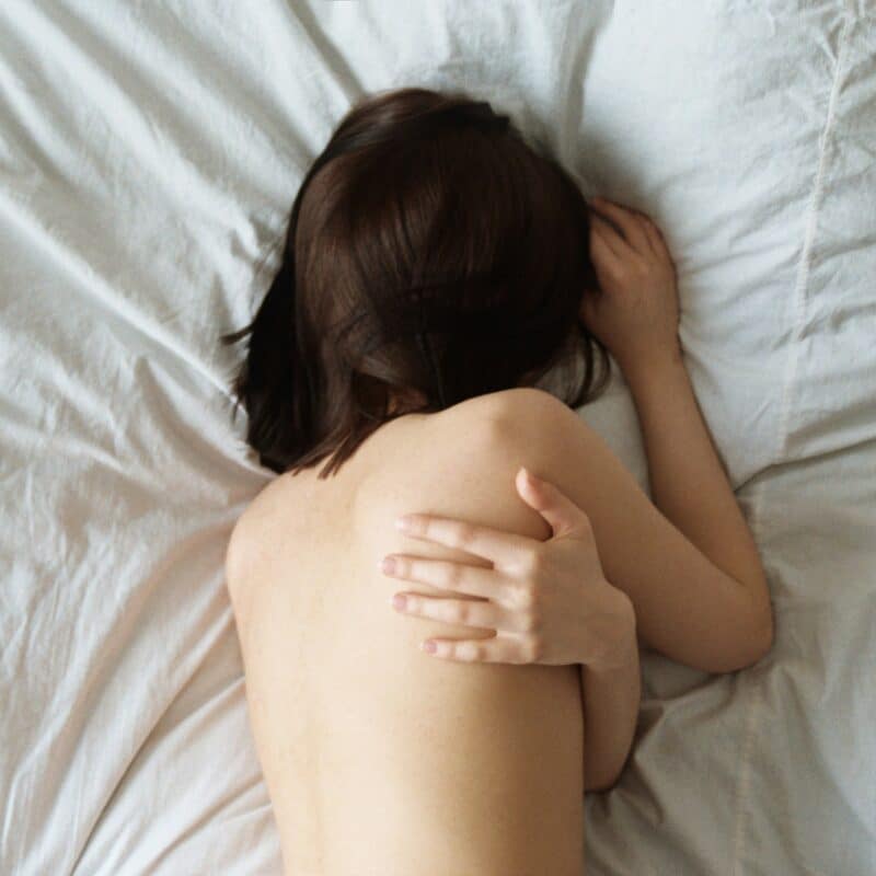 A woman resting in bed due to pelvic pain