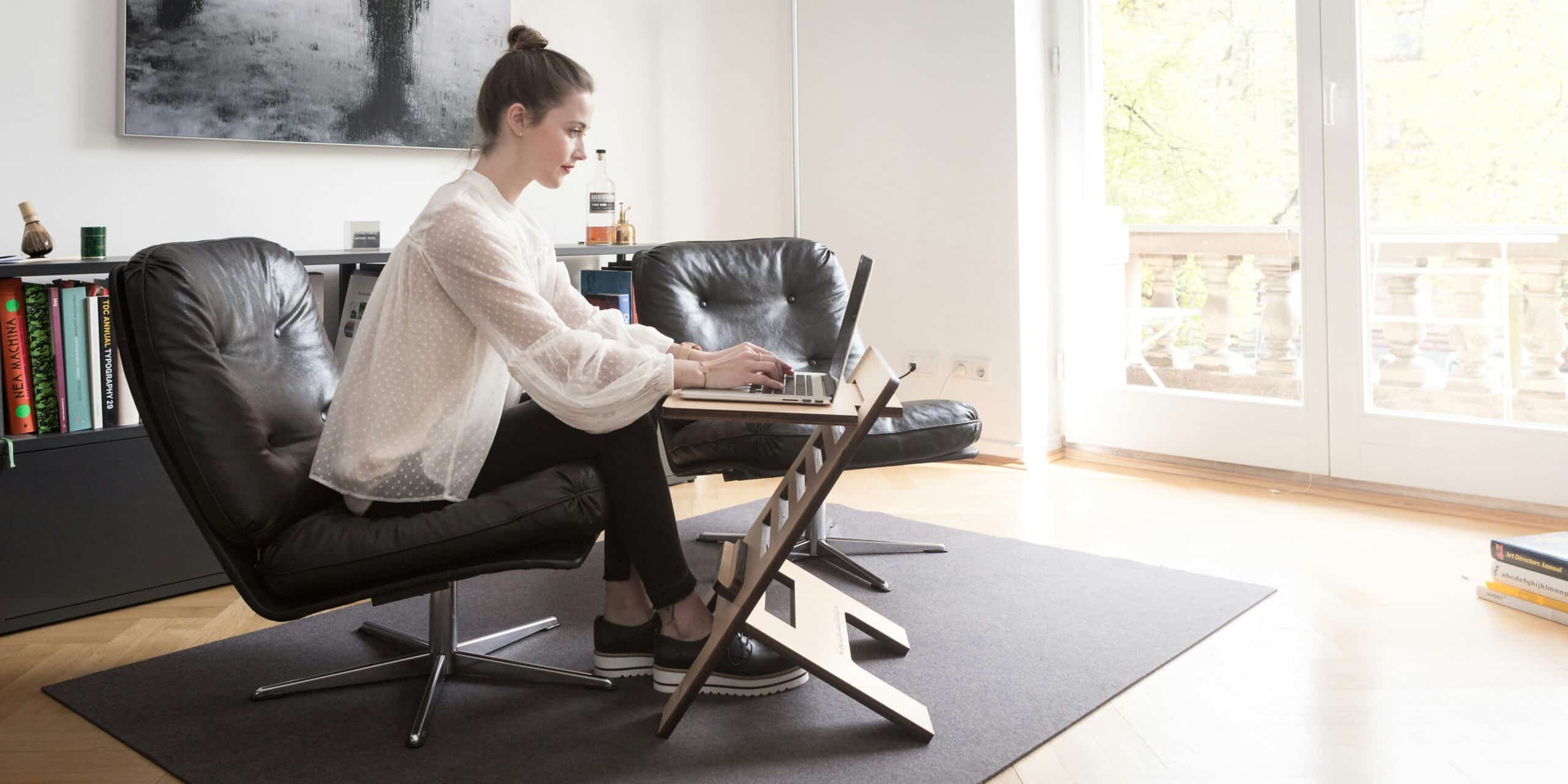 Woman working from home in an ergonomic setup, demonstrating lifestyle adjustments to manage endometriosis-related back pain.