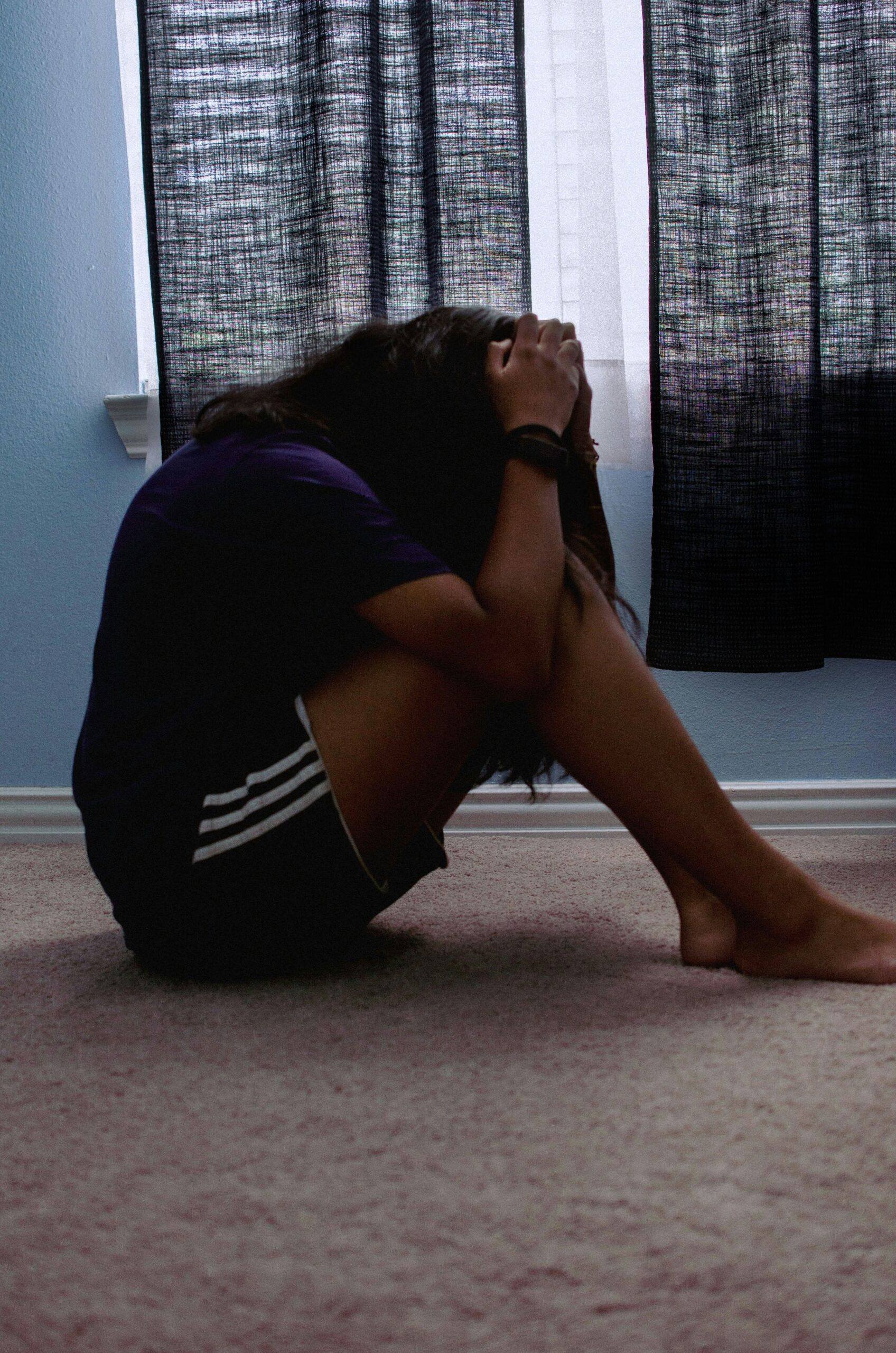 woman sitting on the floor in pain