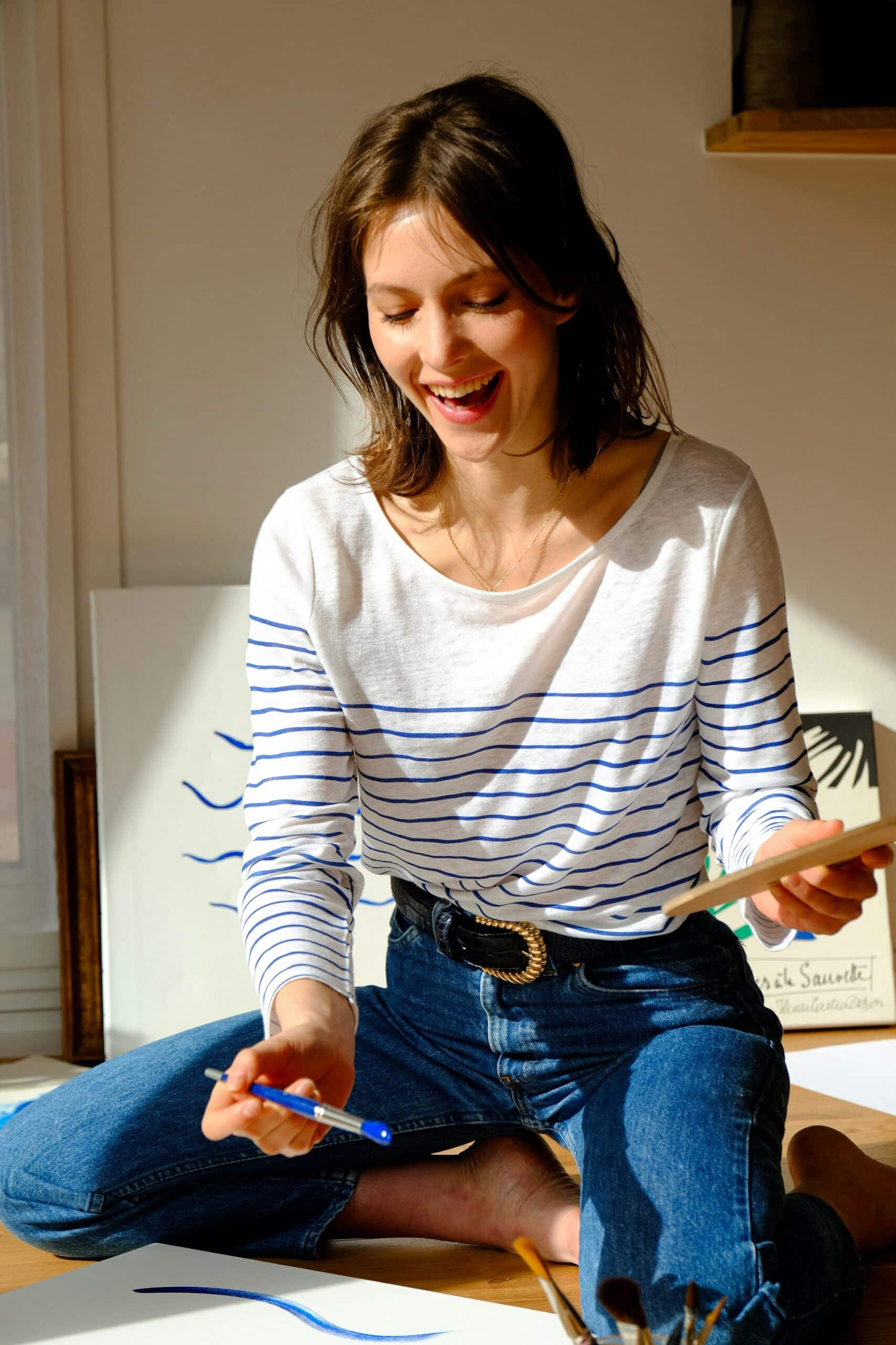 a woman smiling while making art
