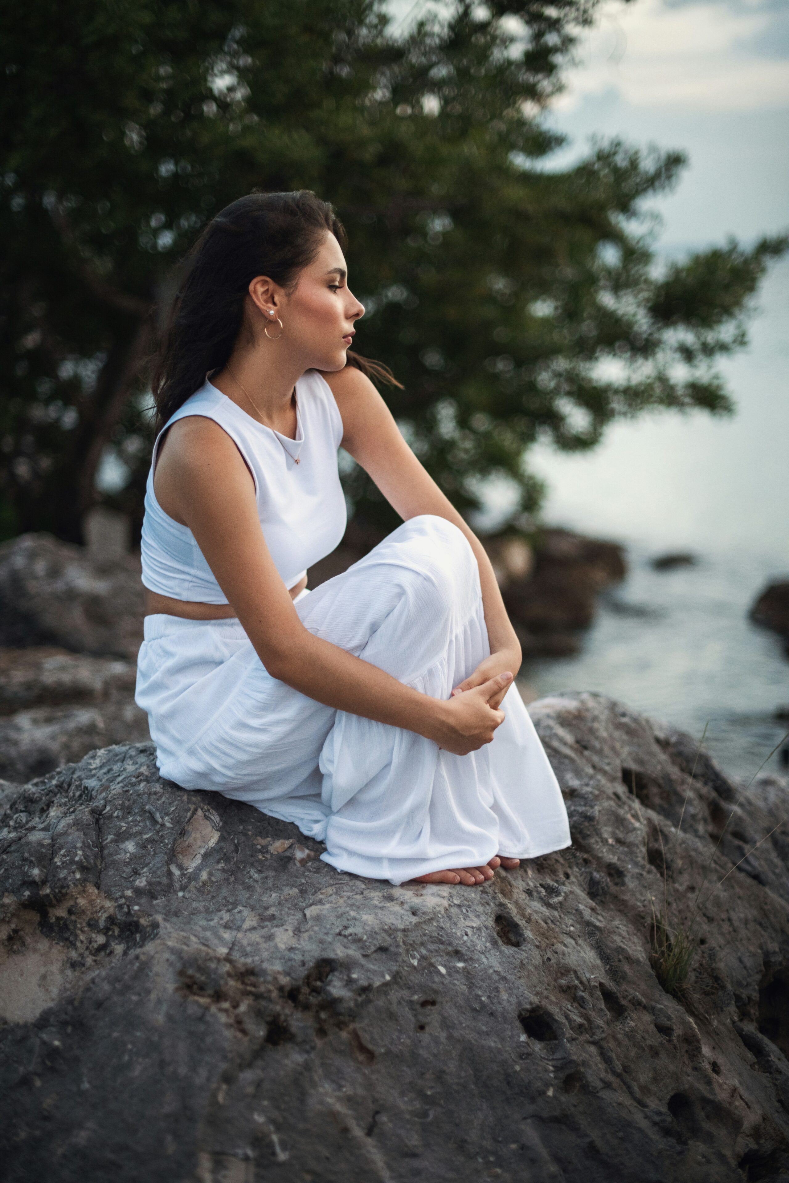a teenage girl sitting by the lake