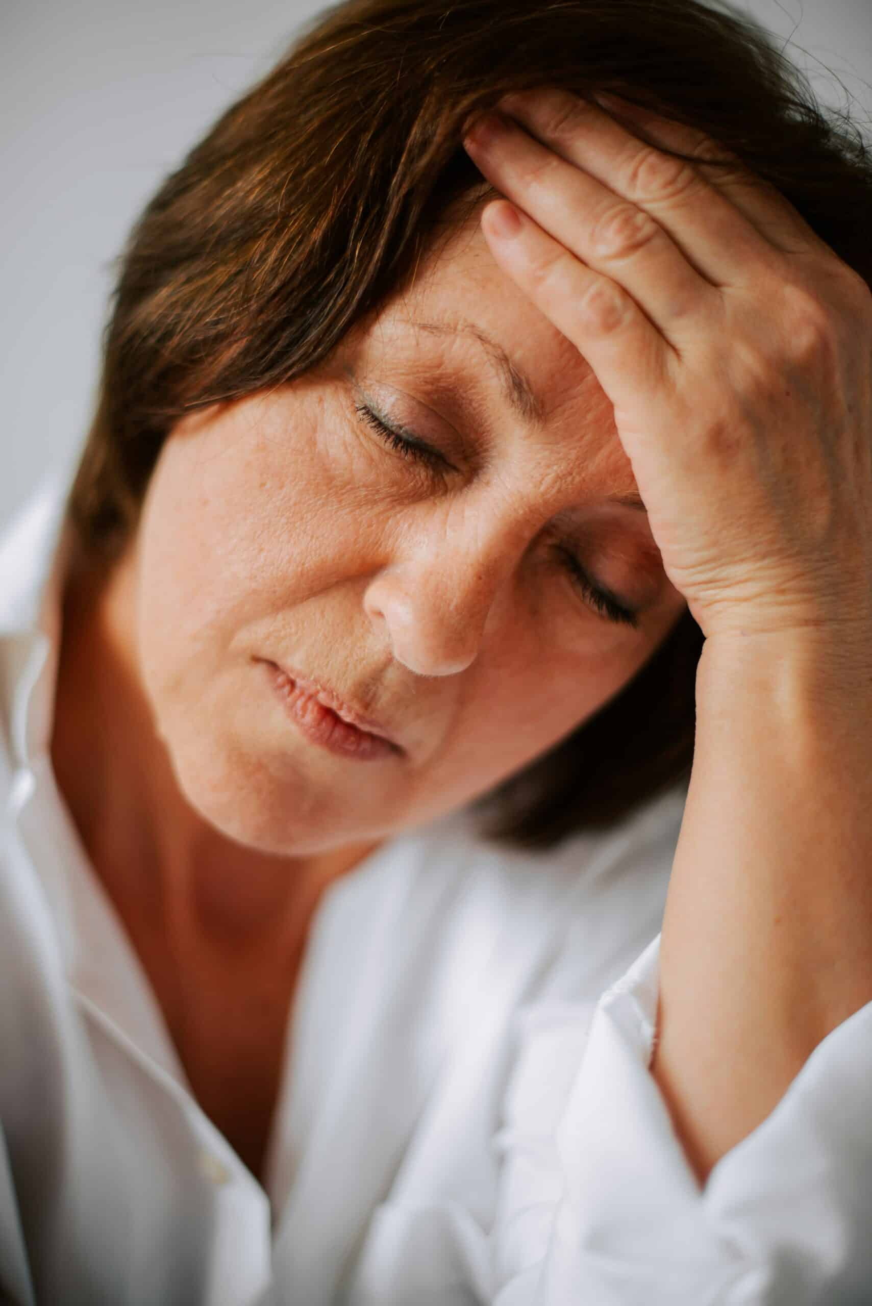 Woman experiencing discomfort or pain, reflecting menopausal symptoms related to endometriosis management.