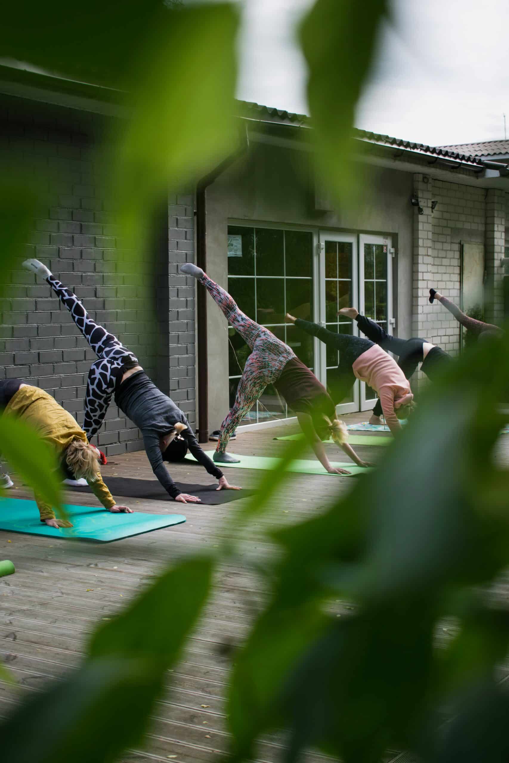 Group of individuals practicing gentle mobility exercises outdoors on yoga mats, emphasizing low-impact movements for endometriosis symptom management and overall well-being.