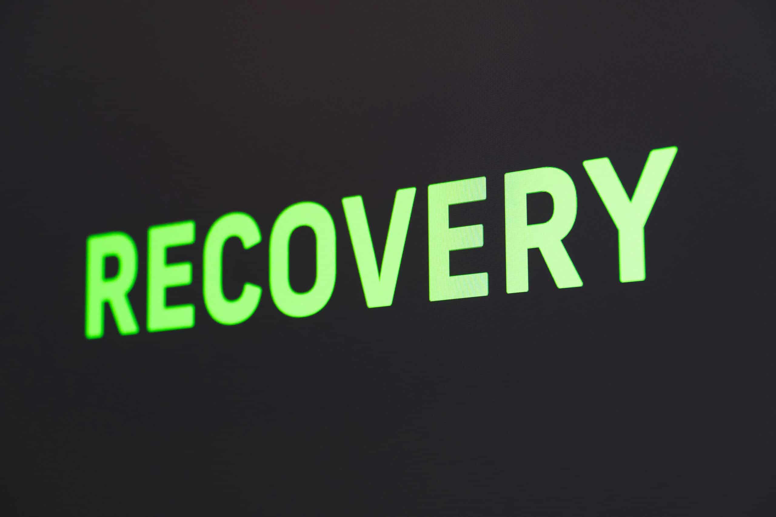 Image with the word ‘Recovery,’ representing the timing of starting pelvic floor therapy after endometriosis excision surgery. - Rachael Haverland Site Green text displaying "RECOVERY" on a dark background, symbolizing healing and rehabilitation in the context of pelvic floor therapy for endometriosis recovery.