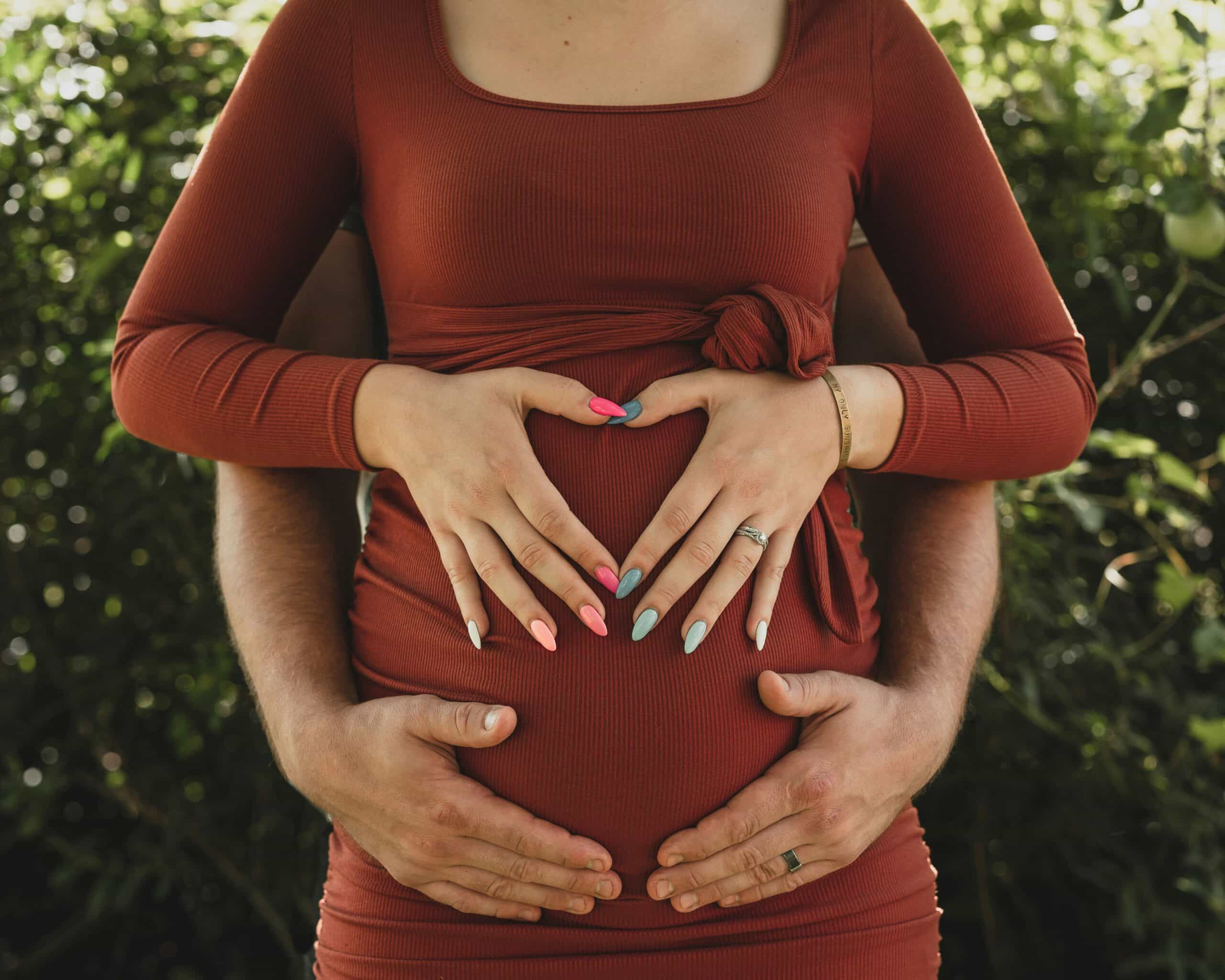 Woman holding her stomach while a man stands behind her offering support, illustrating how physical therapy can help relieve endometriosis symptoms through pain management and emotional support.