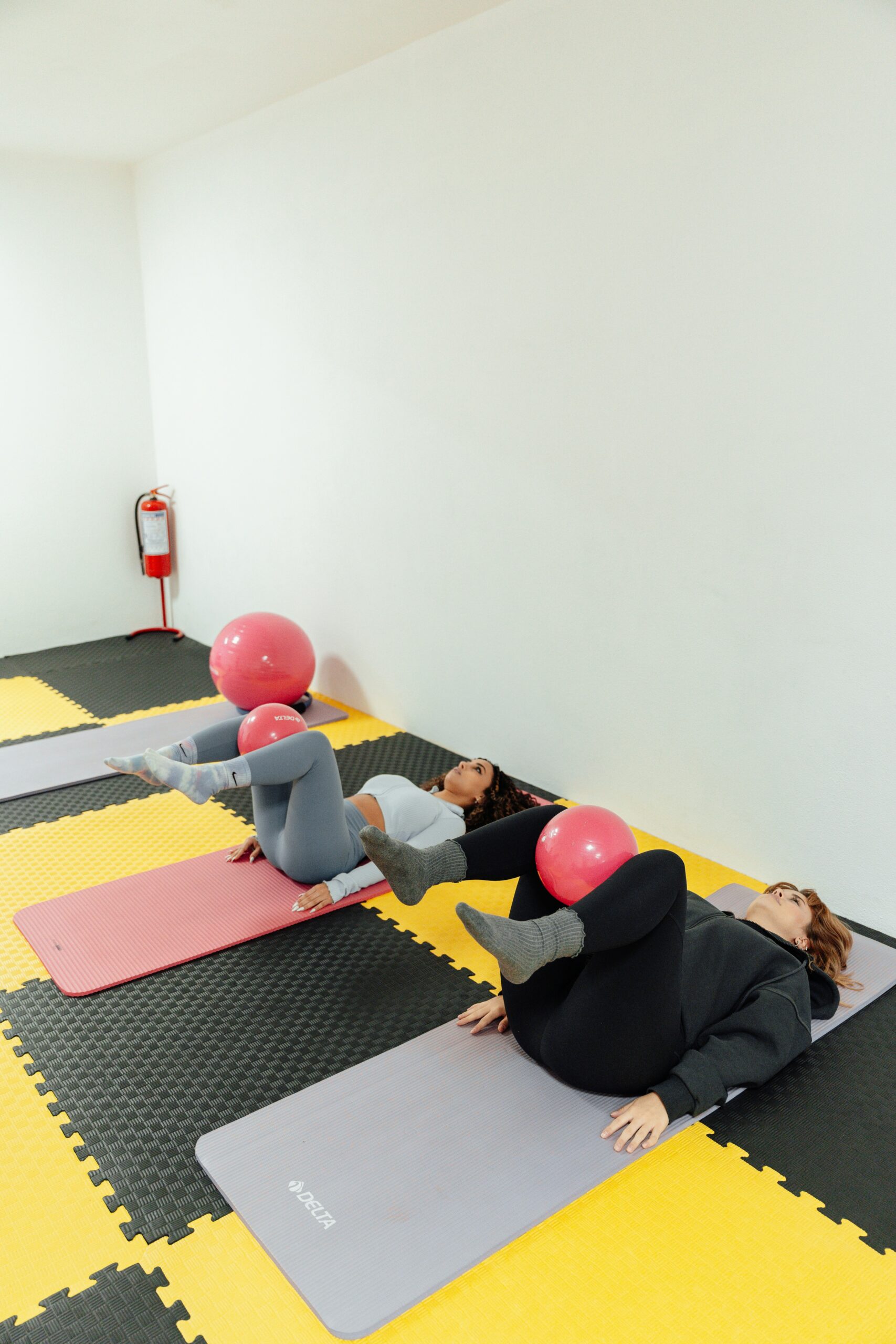 Several women performing floor exercises, demonstrating pelvic floor exercises that can help ease endometriosis symptoms. - Rachael Haverland Site Women practicing pelvic floor relaxation exercises with exercise balls on mats, emphasizing techniques to alleviate endometriosis-related pelvic pain.