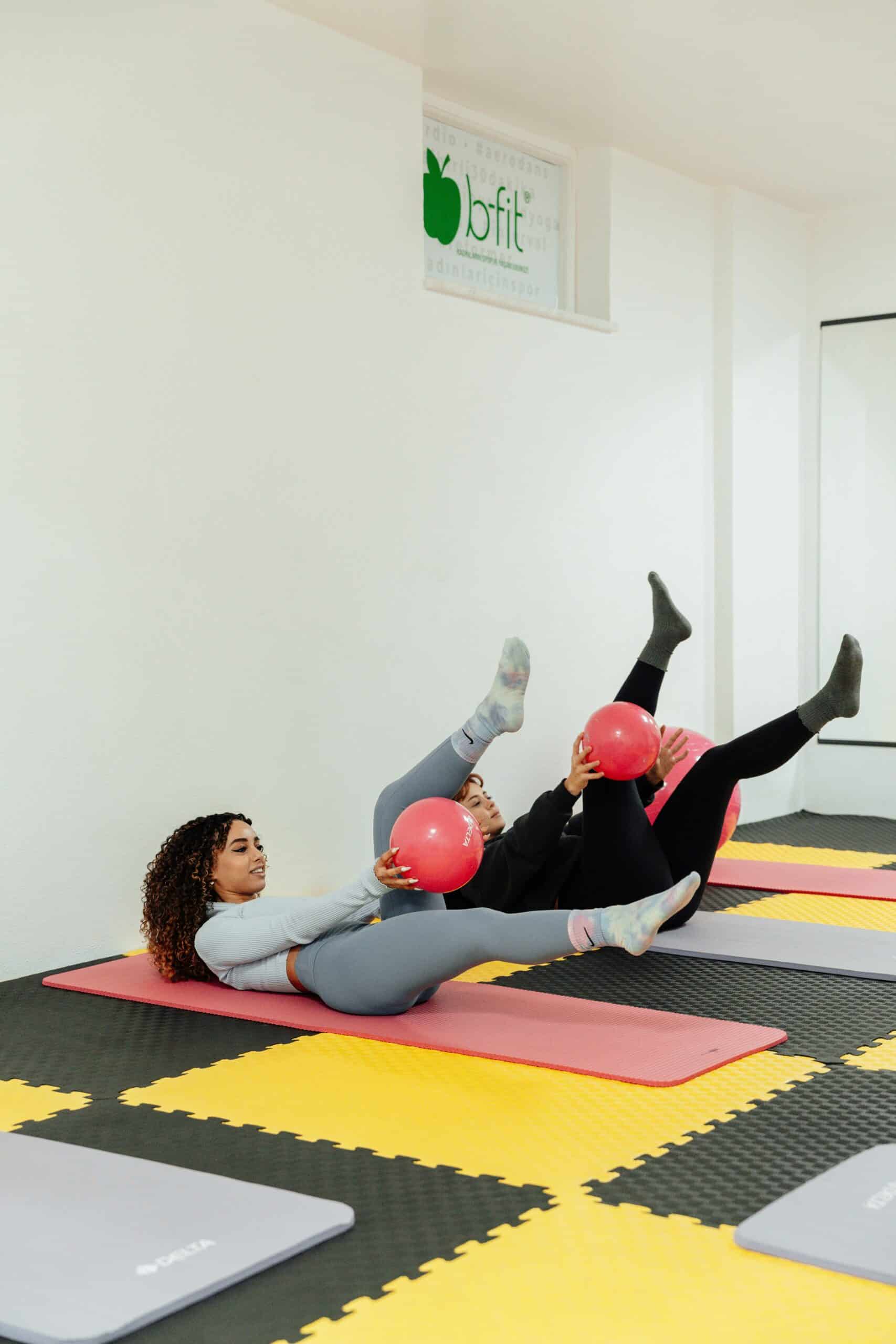 Women performing pelvic floor exercises with small pink balls on exercise mats, emphasizing coordination and strength for managing endometriosis symptoms.