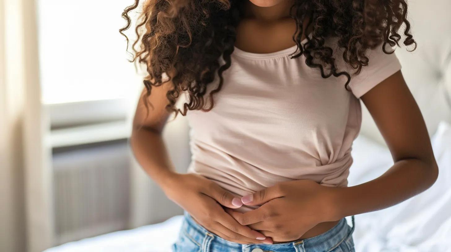 Teen girl holding her lower abdomen in discomfort