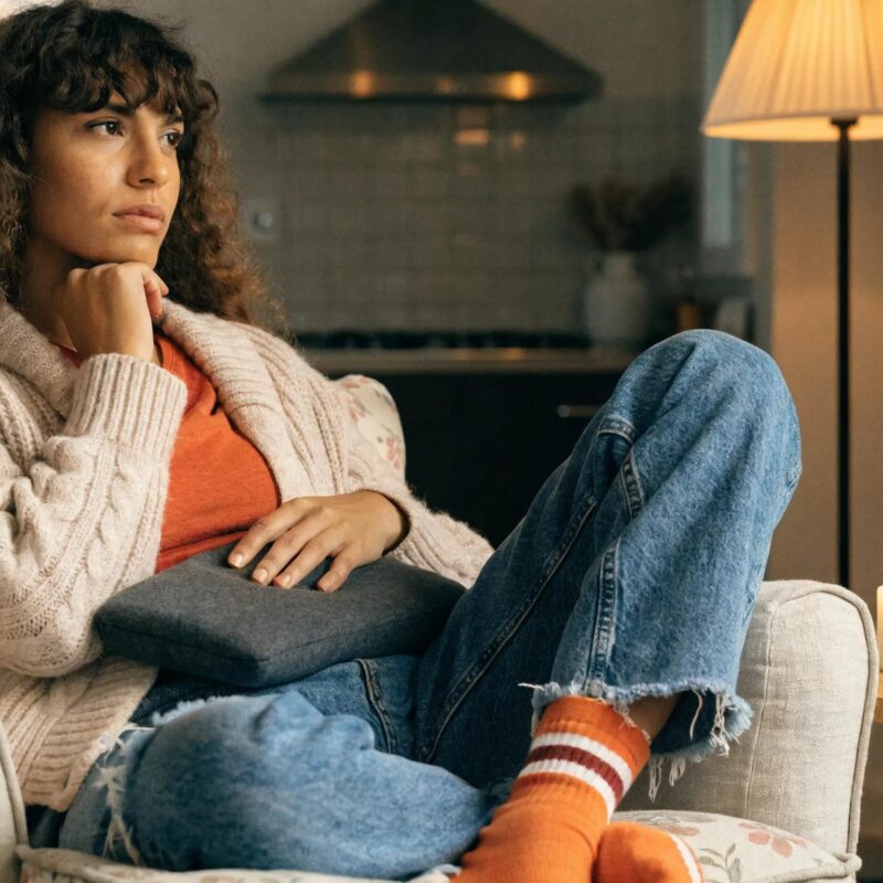 Woman using a heating pad, representing the experience of endometriosis symptoms