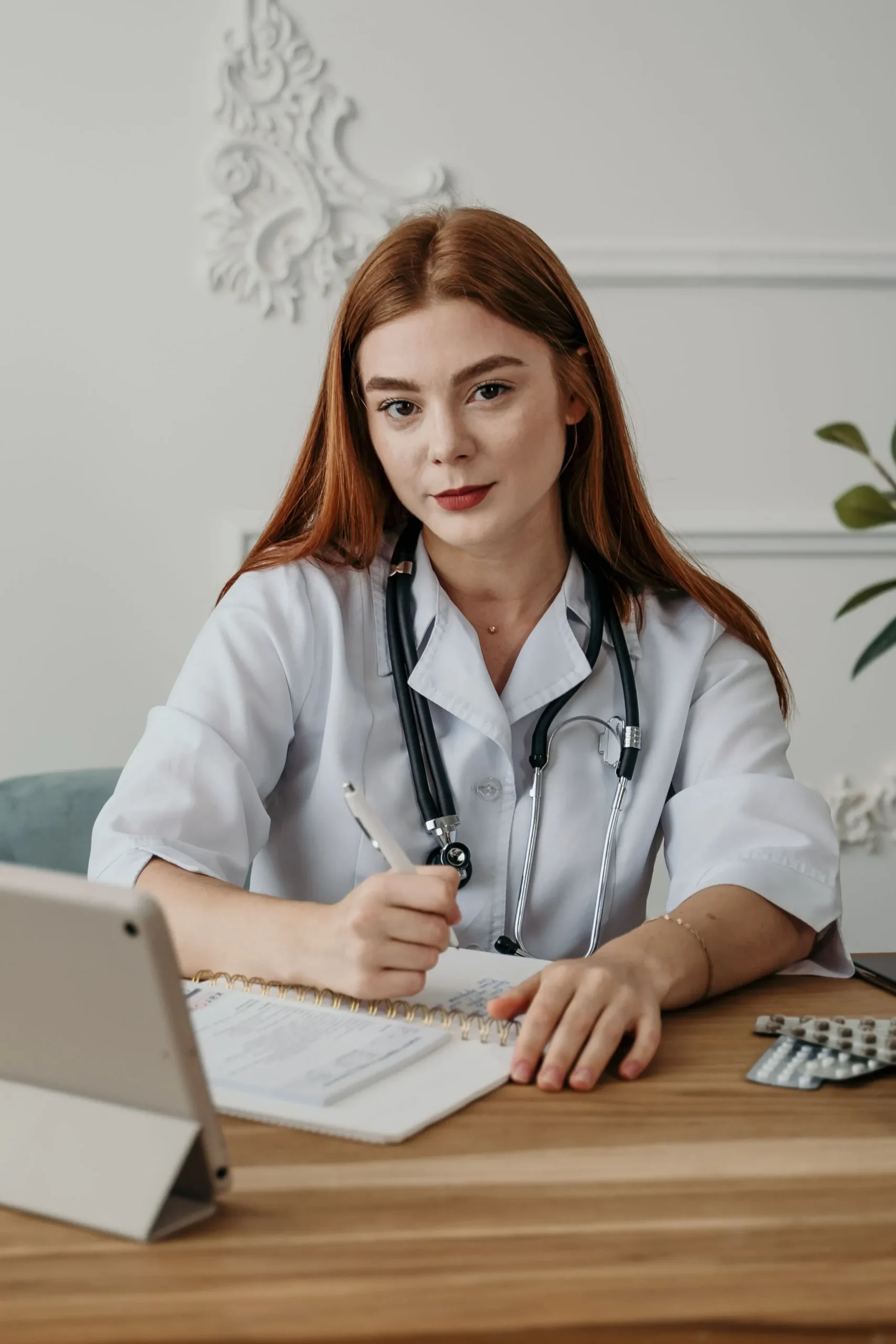 A female doctor prescribing something on a letter pad