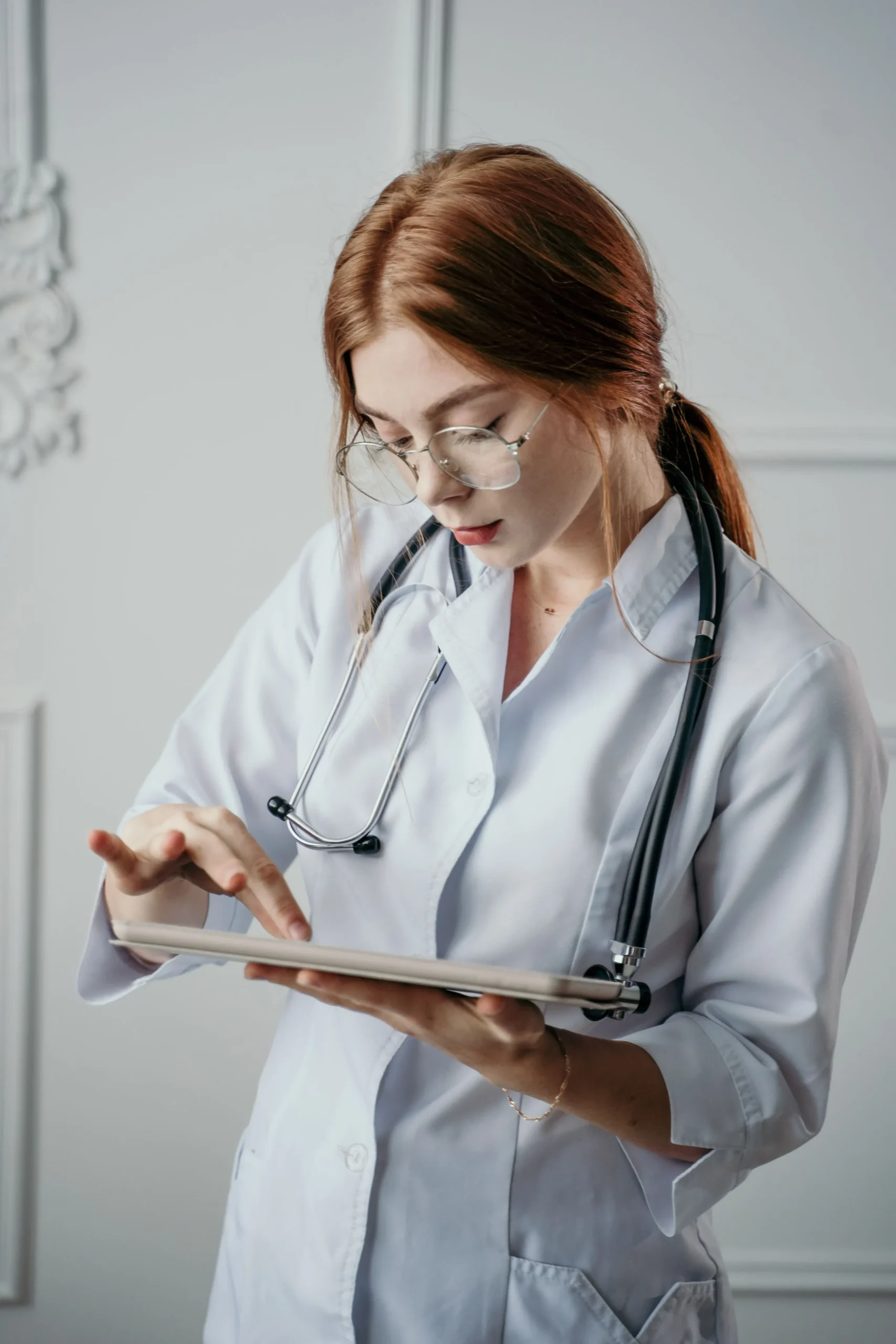 A female doctor writing something on the tablet