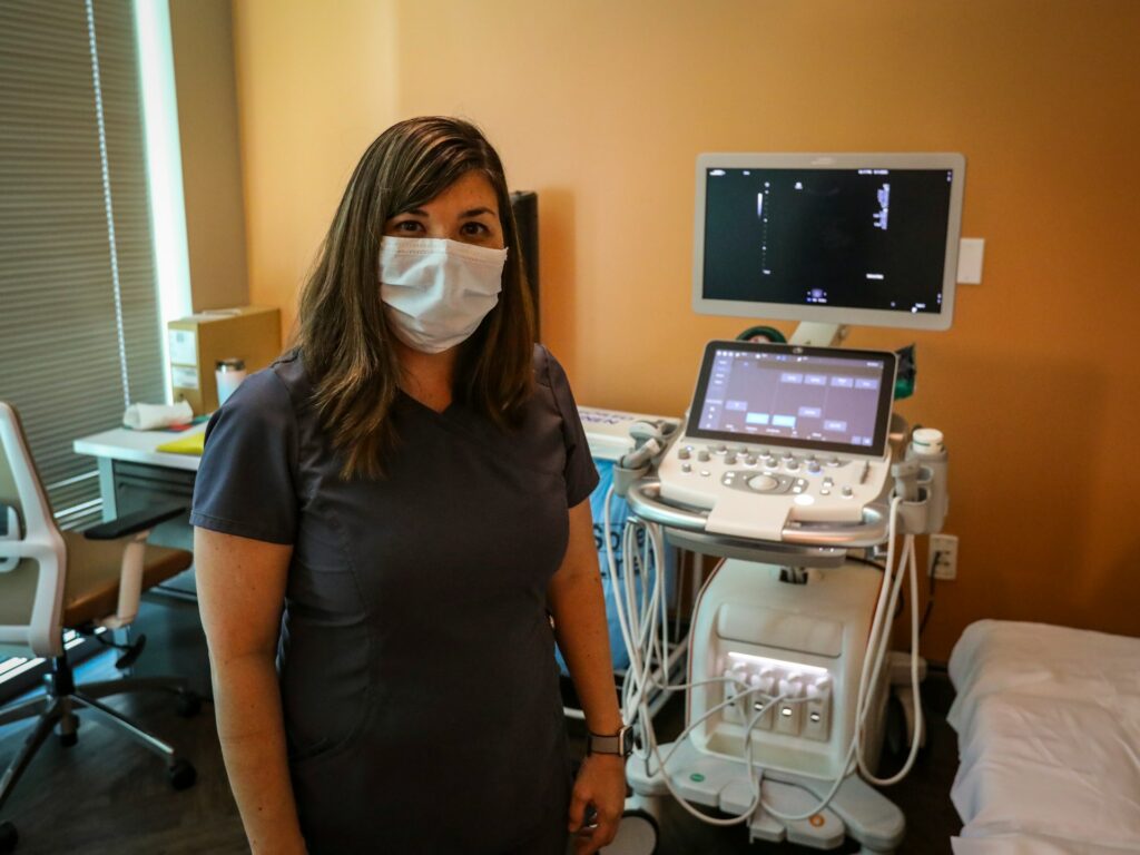 Woman healthcare provider with ultrasound equipment for endometriosis evaluation and diagnosis.