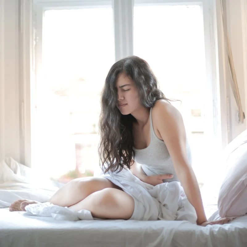 A woman waking up with stomach pain
