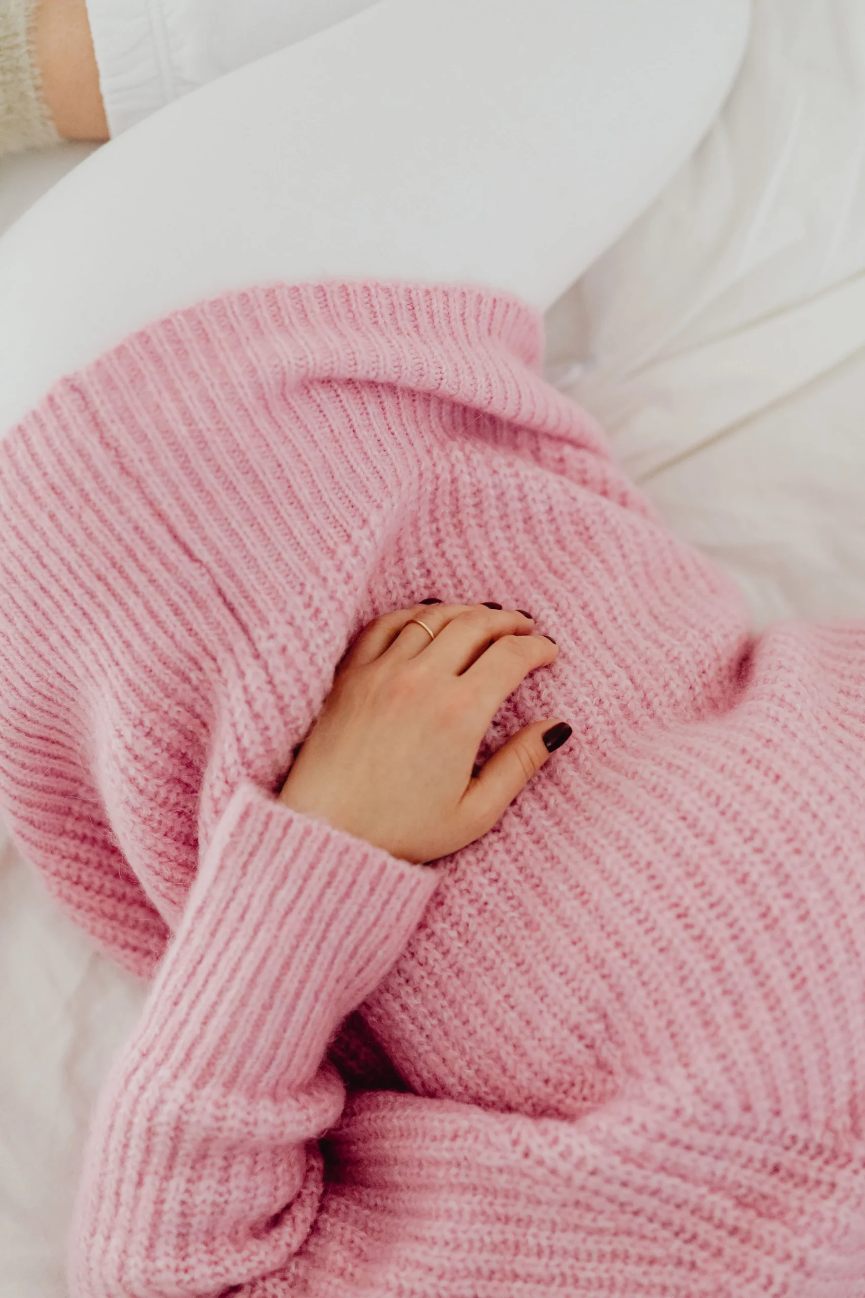 A woman laying down with her hand on her stomach